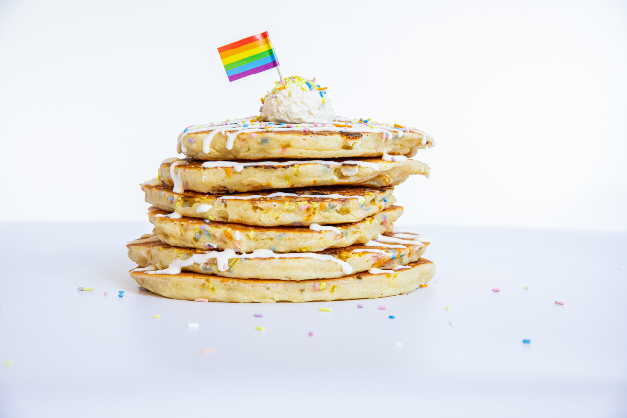 A stack of pancakes with a rainbow flag for Pride.