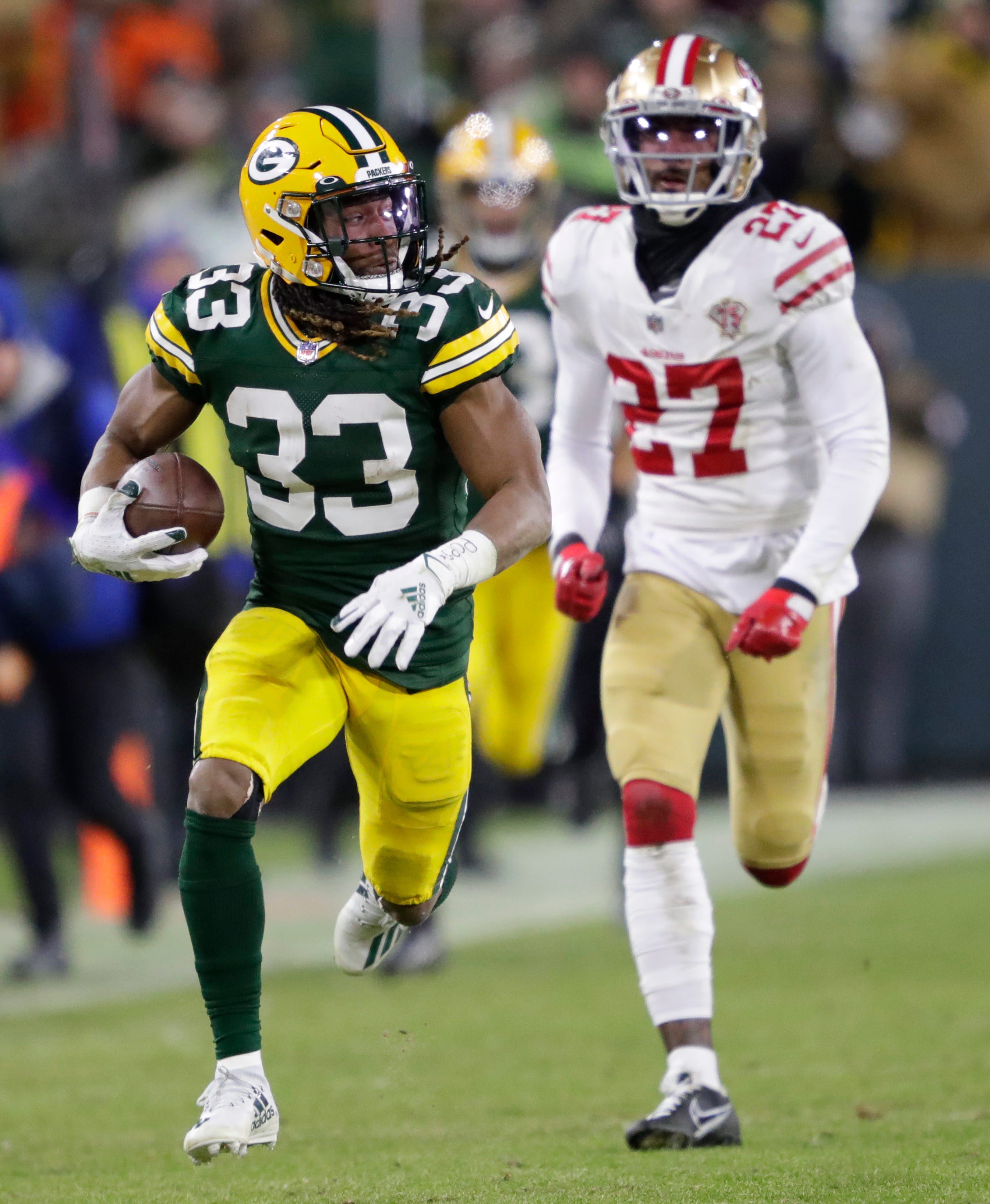 Green Bay Packers running back Aaron Jones (33) breaks away on a long reception against San Francisco 49ers defensive back Dontae Johnson (27) in the second quarter during their NFL divisional round football playoff game Saturday January 22, 2022, at Lambeau Field in Green Bay,&nbsp;