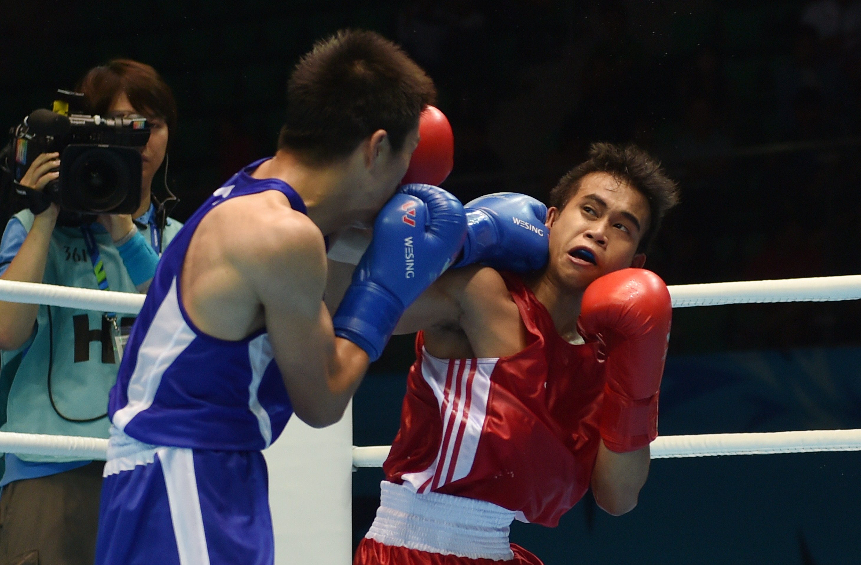 Mark Anthony Barriga (R) of the Philippines competes against Tosho Kashiwasaki (L) of Japan during the boxing preliminaries session 10 at the 17th Asian Games in Incheon on September 28, 2014.