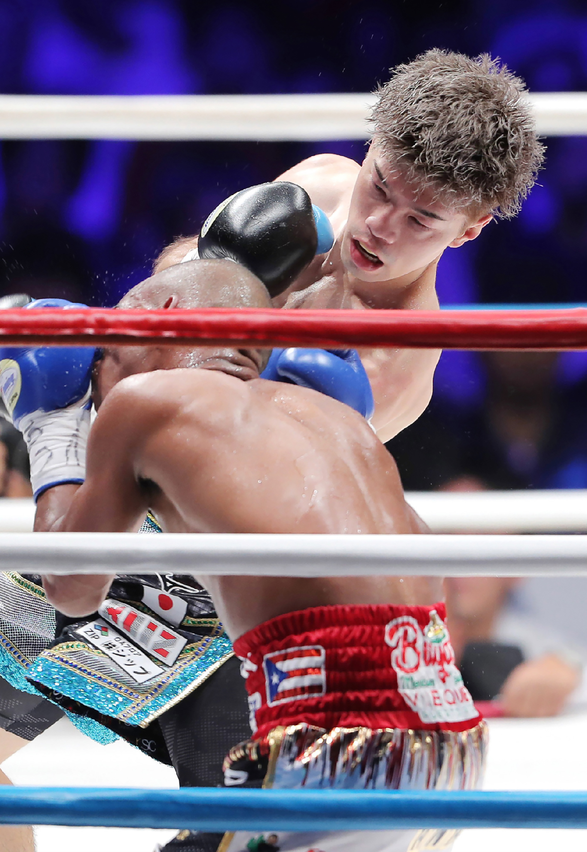 Japan’s Kosei Tanaka (top) fights against Puerto Rico’s Jonathan Gonzalez (bottom) during their WBO flyweight title boxing match in Nagoya on August 24, 2019.