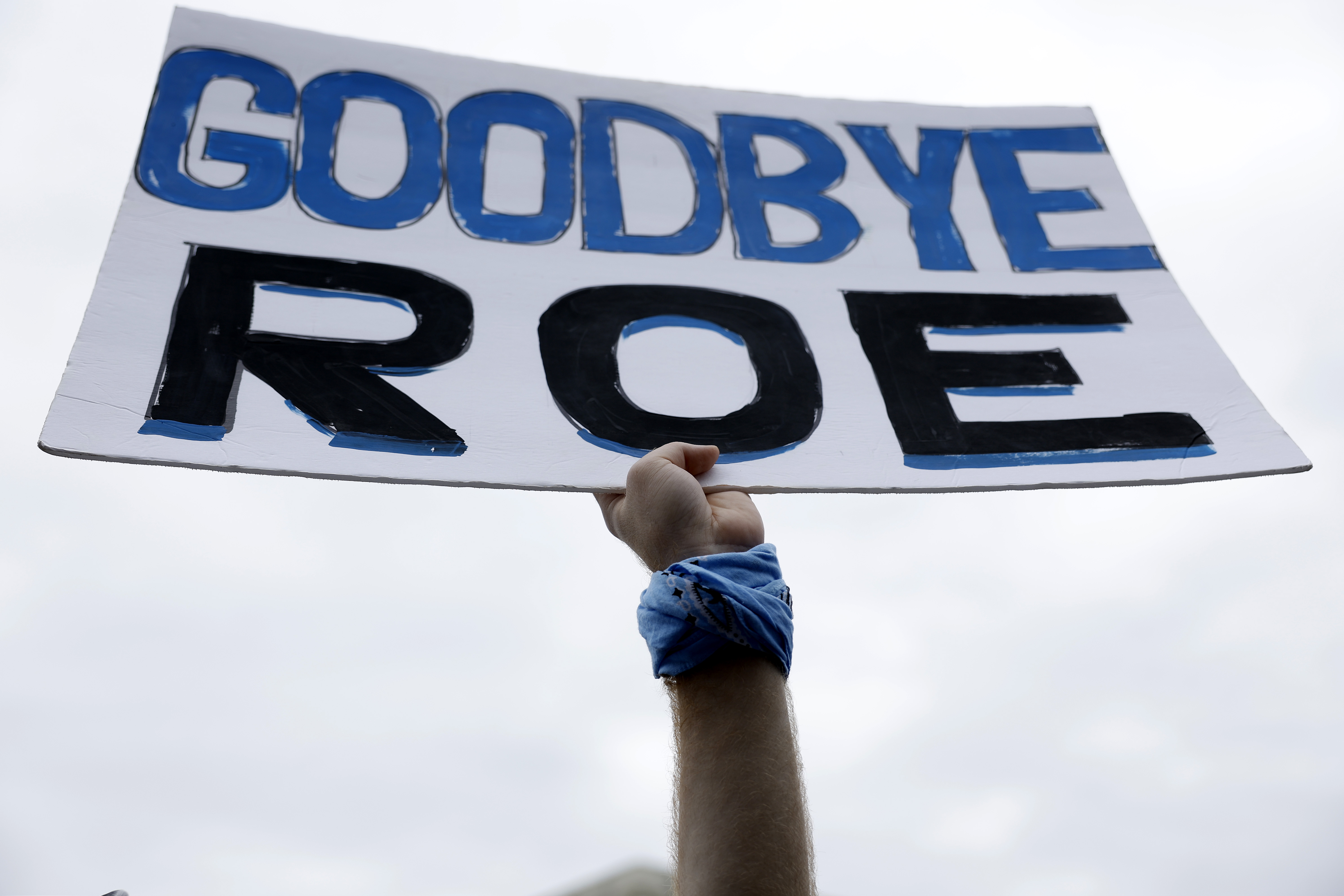 Anti-abortion protester holds sign saying “Goodbye Roe”