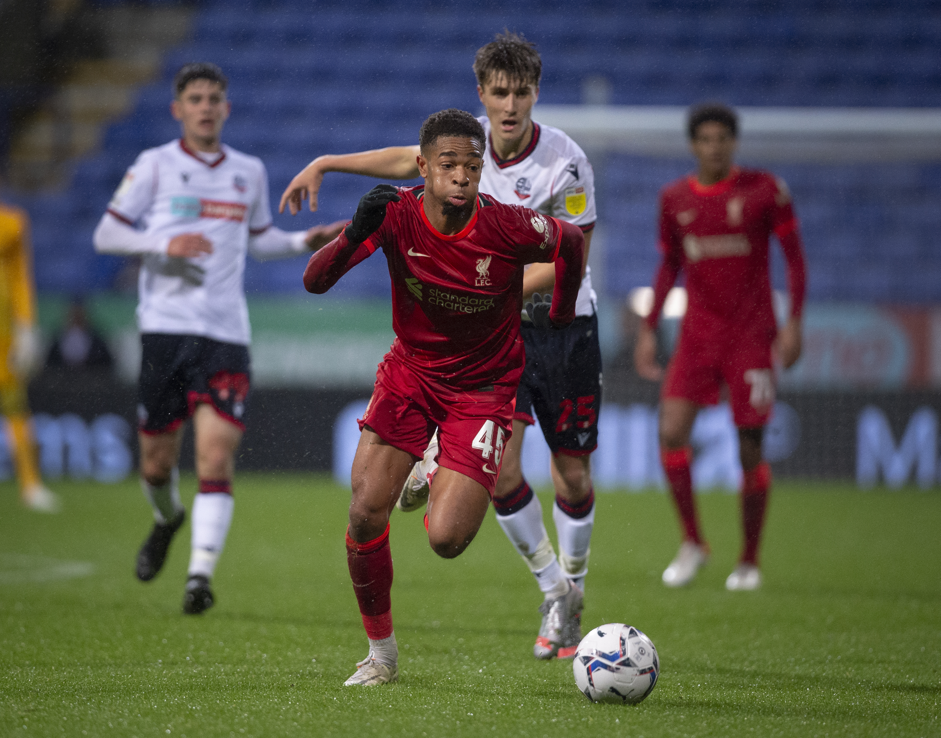 Elijah Dixon Bonner of Liverpool and George Thomason of Bolton Wanderers in action with Jarrell Quansah of Liverpool and Arran Pettifer of Bolton Wanderers during the Papa John’s EFL Trophy Northern Group D match between Bolton Wanderers and Liverpool U21’s at University of Bolton Stadium on October 5, 2021 in Bolton, England.