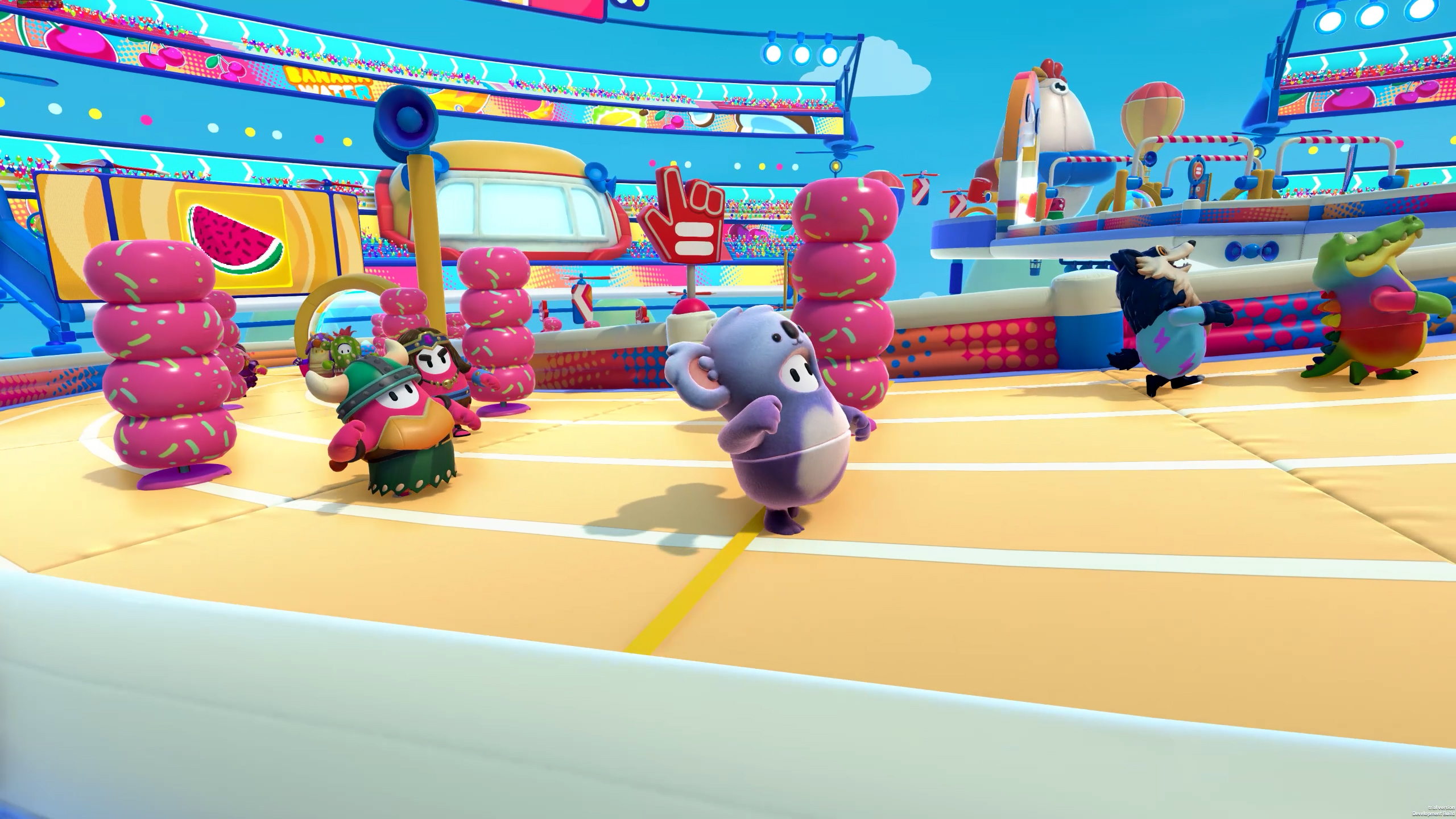 Various beans compete on a race track, avoiding stacks of donuts, in a screenshot from Fall Guys