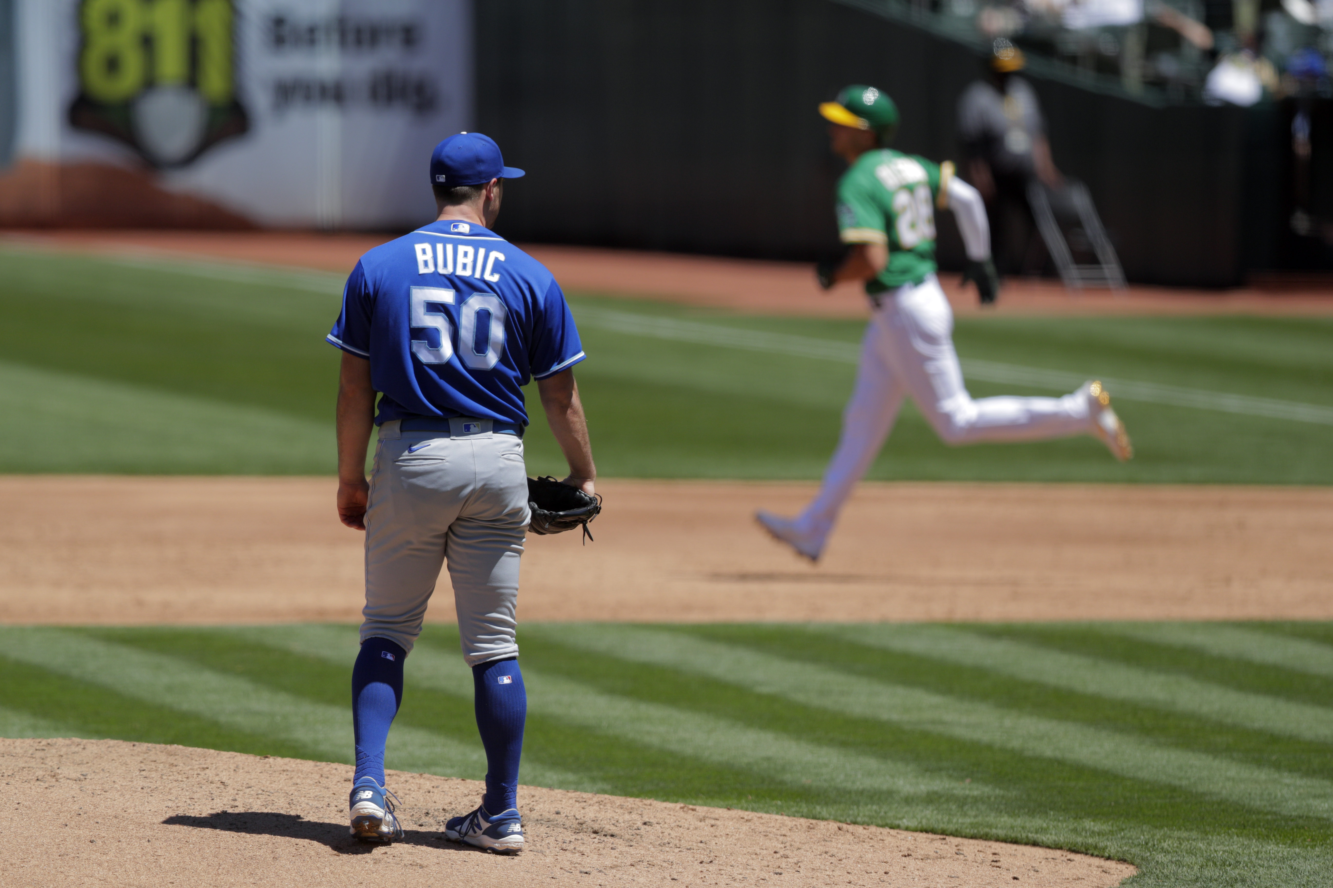 Kris Bubic (50) back on the mound watching Matt Olson (28) round.the bases after hitting his third inning homerun as the Oakland Athletics played the Kansas City Royals at the Coliseum in Oakland, Calif., on Sunday, June 13, 2021.
