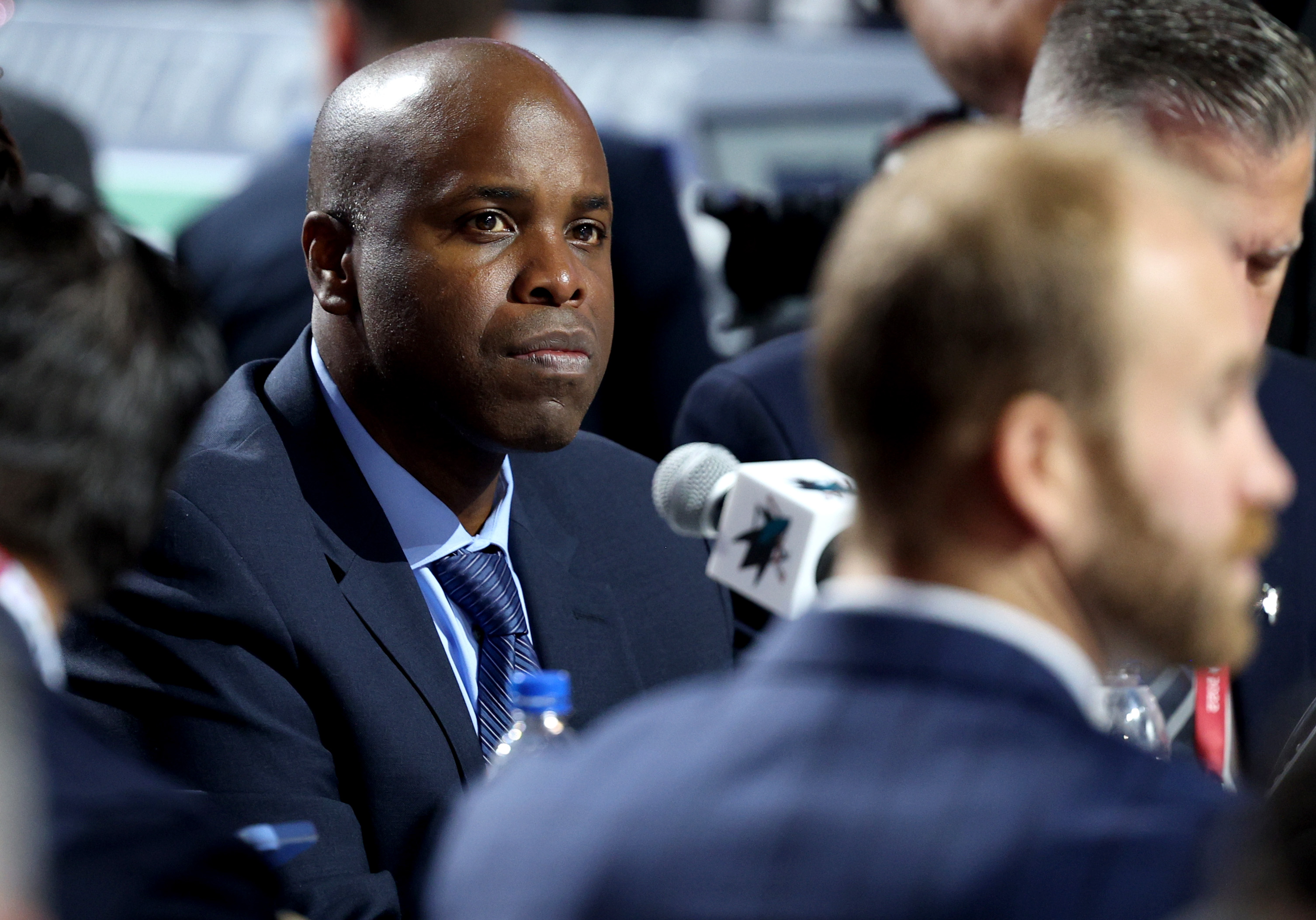 General manager Mike Grier of the San Jose Sharks looks on from the draft table during the 2022 Upper Deck NHL Draft at Bell Centre on July 08, 2022 in Montreal, Quebec.