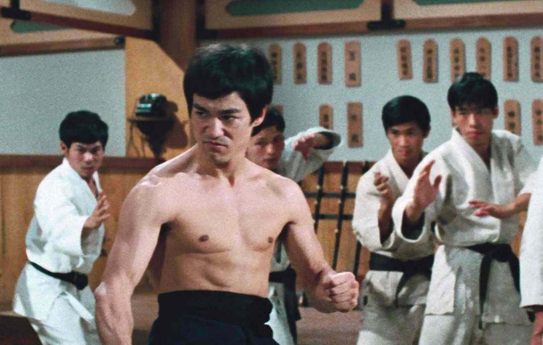 a shirtless Bruce Lee is ready for a fight in Fist of Fury