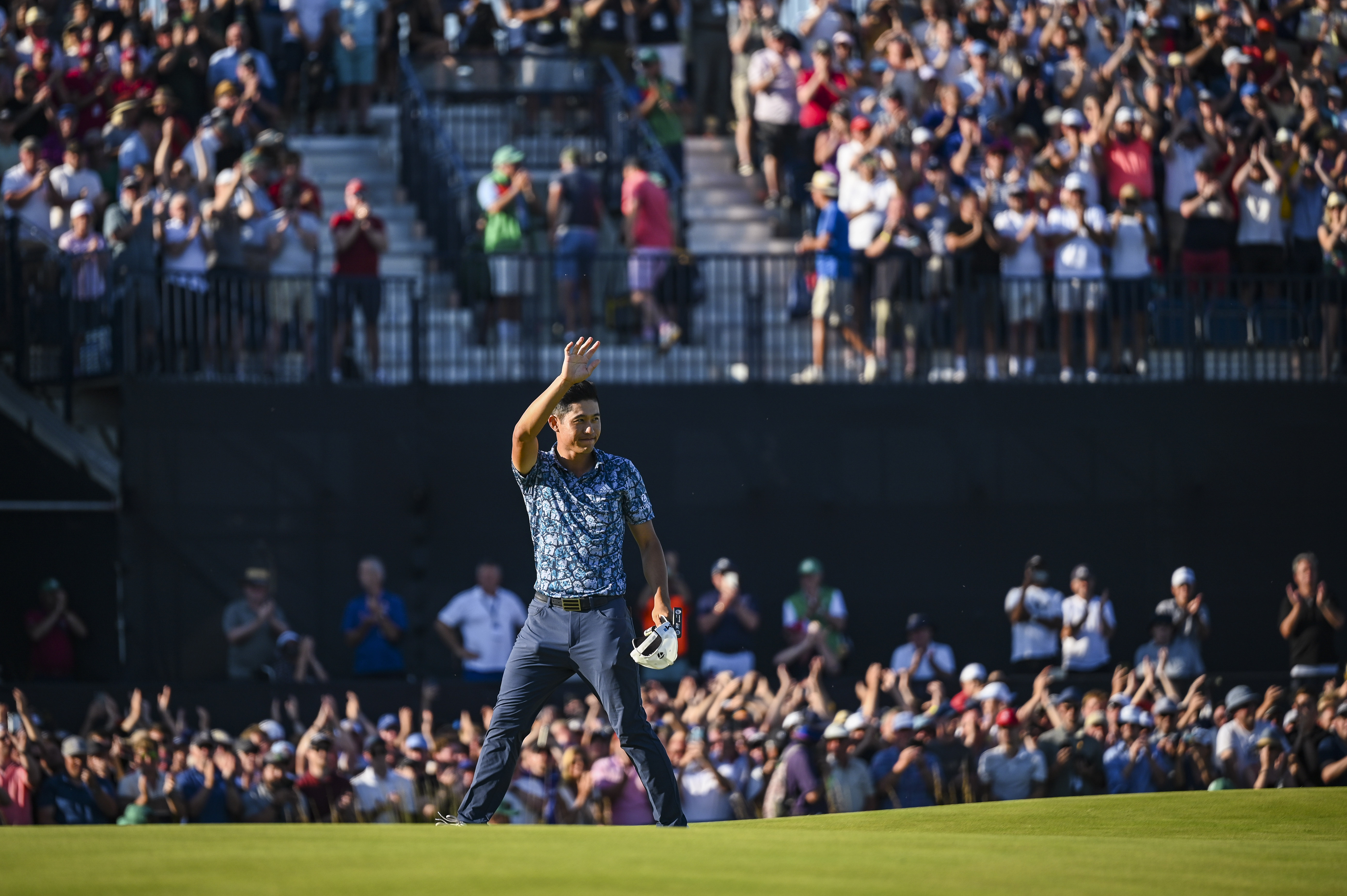 Collin Morikawa smiles and waves to fans following his two stroke victory on the 18th hole green during Day Four of the 149th The Open Championship at Royal St. Georges Golf Club on July 18, 2021 in Sandwich, England.