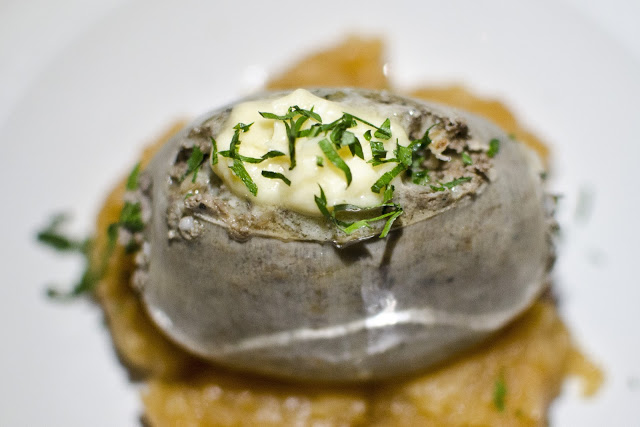 A portion of haggis sits on a bed of mashed rutabaga, garnished with Drambuie butter