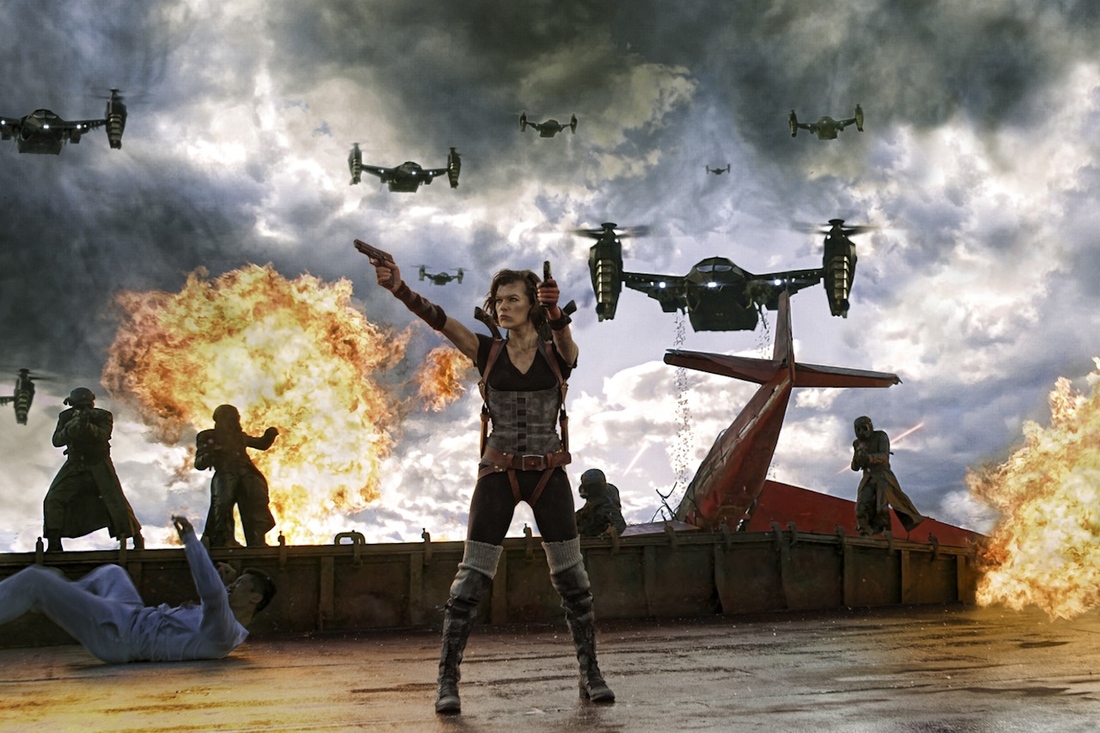 Milla Jovovich as Alice firing guns with explosions in the background in Resident Evil: Retribution.