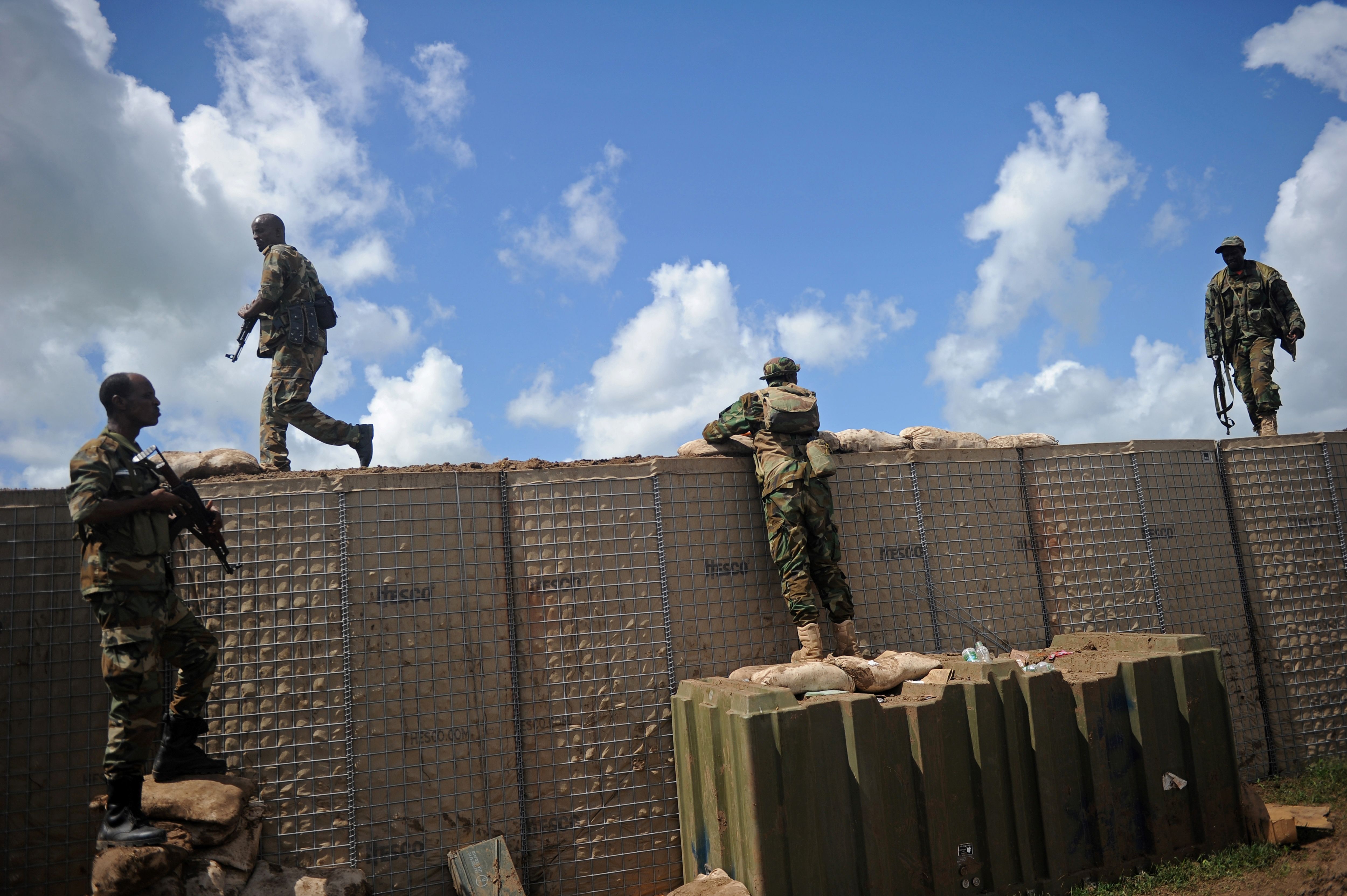 Soldiers atop a barricade wall.