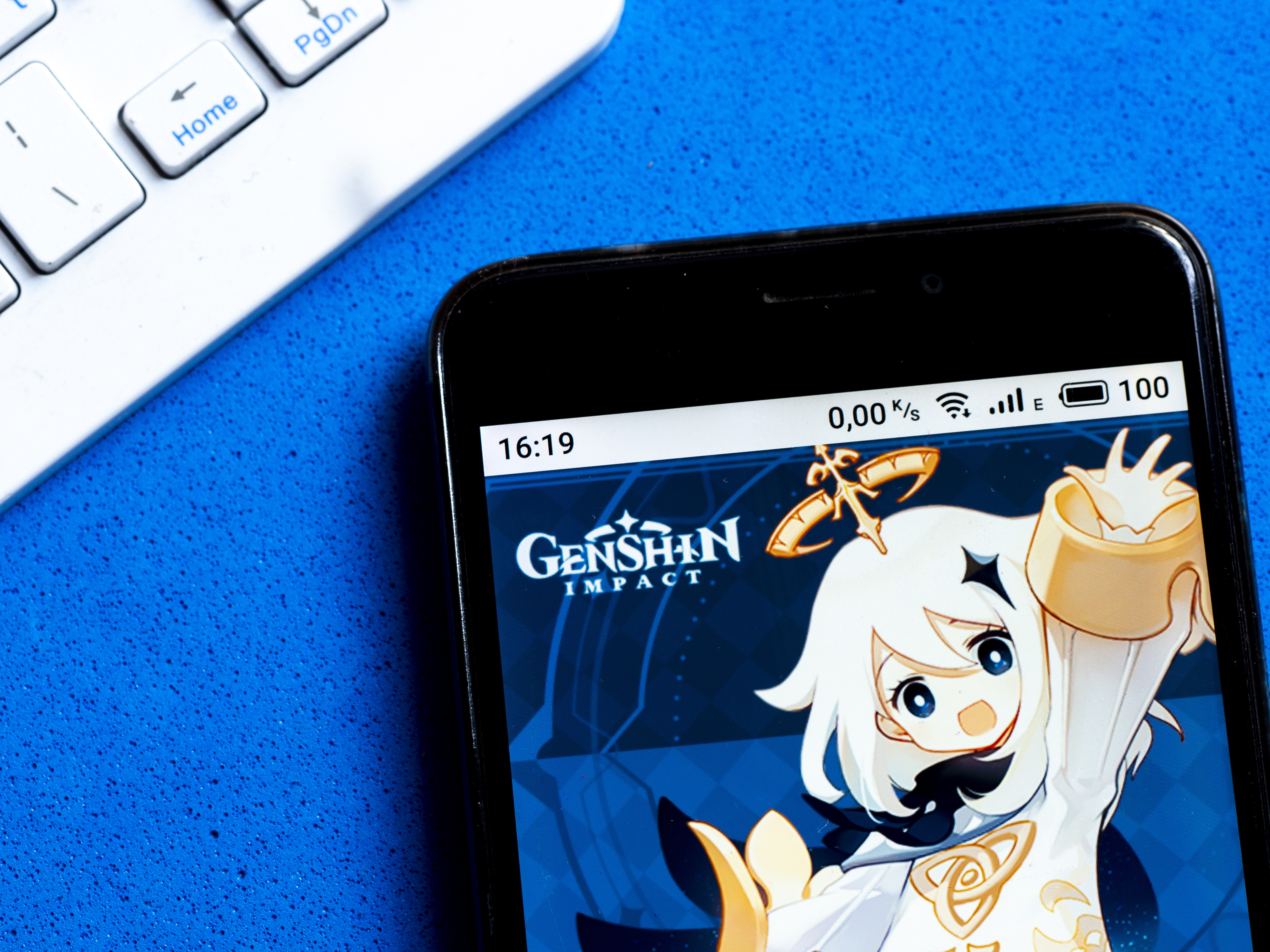 A phone with a backdrop that features an illustration of the Genshin Impact app by miHoYo