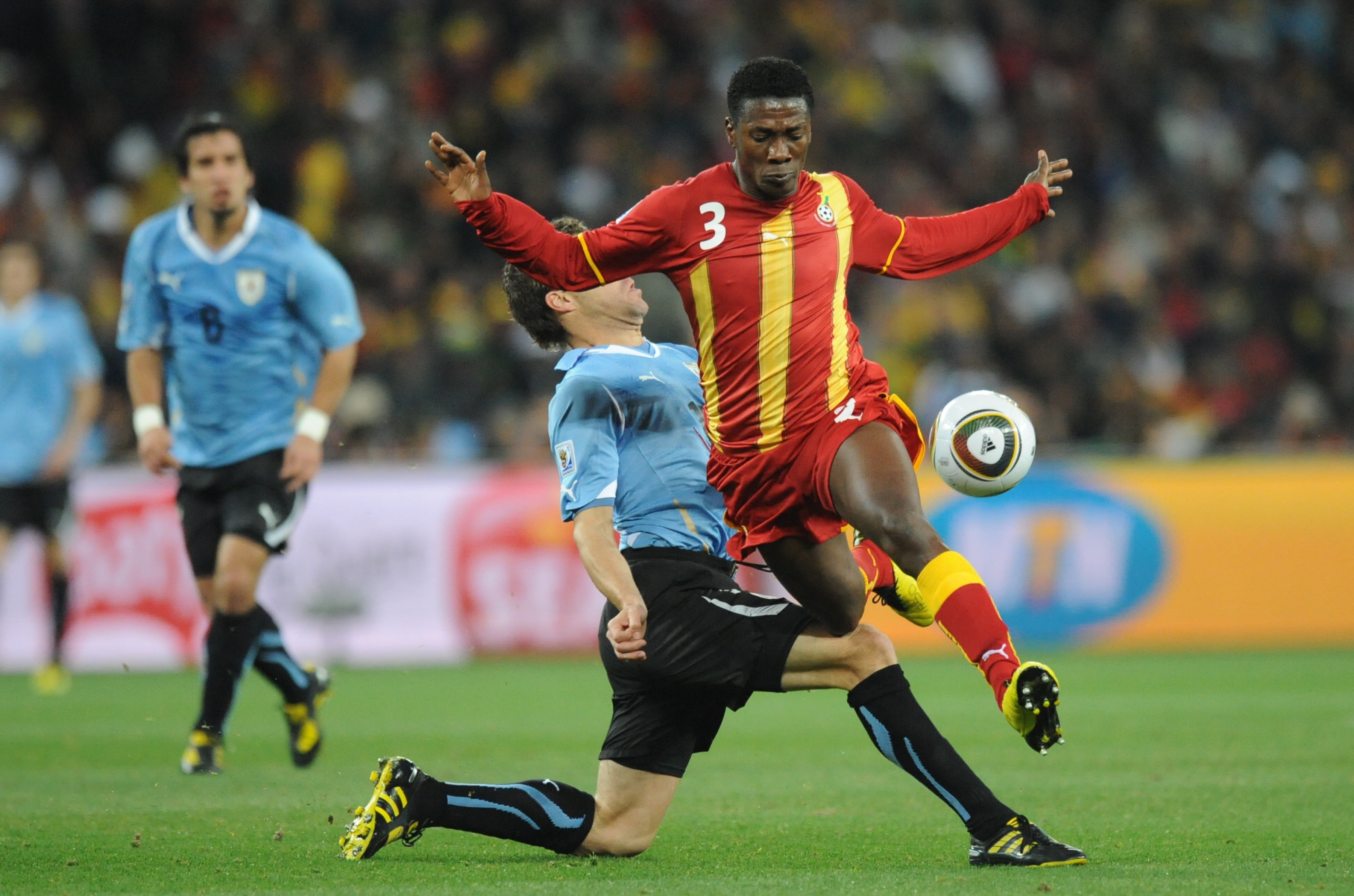 Ghana’s striker Asamoah Gyan (R) vies wi