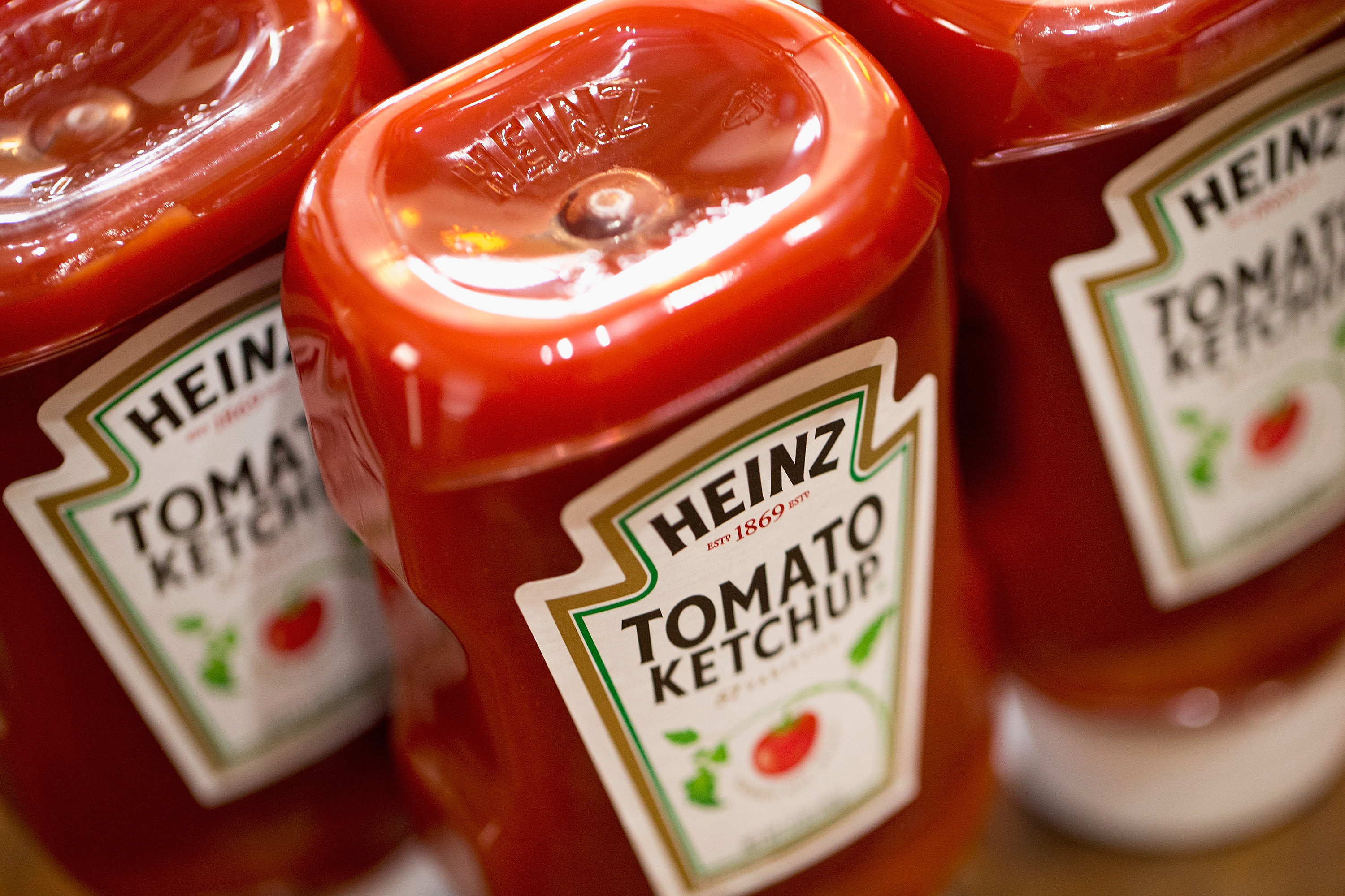 Close-up of three bottles of Heinz tomato ketchup.