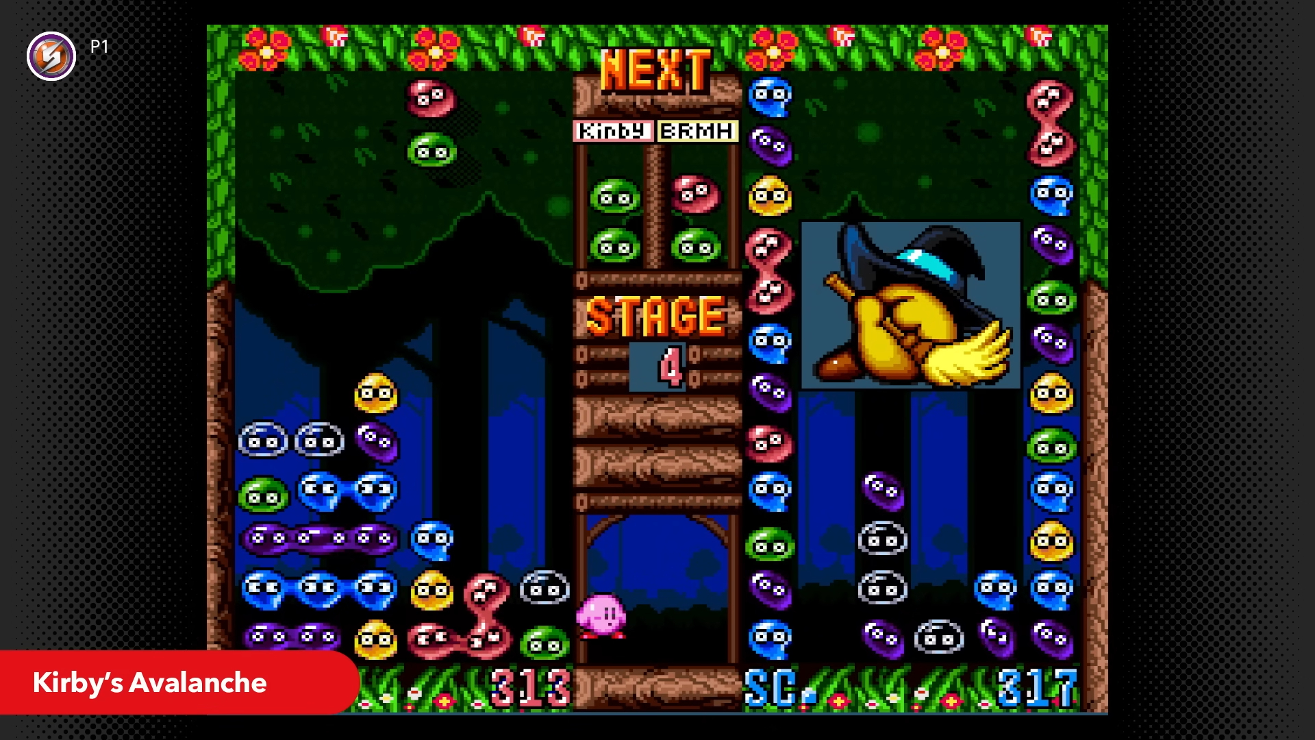 A screenshot from Kirby’s Avalanche, showing two columns of multicolored blobs stacked on top of each other, as additional blobs fall from the top of the screen onto the stack.