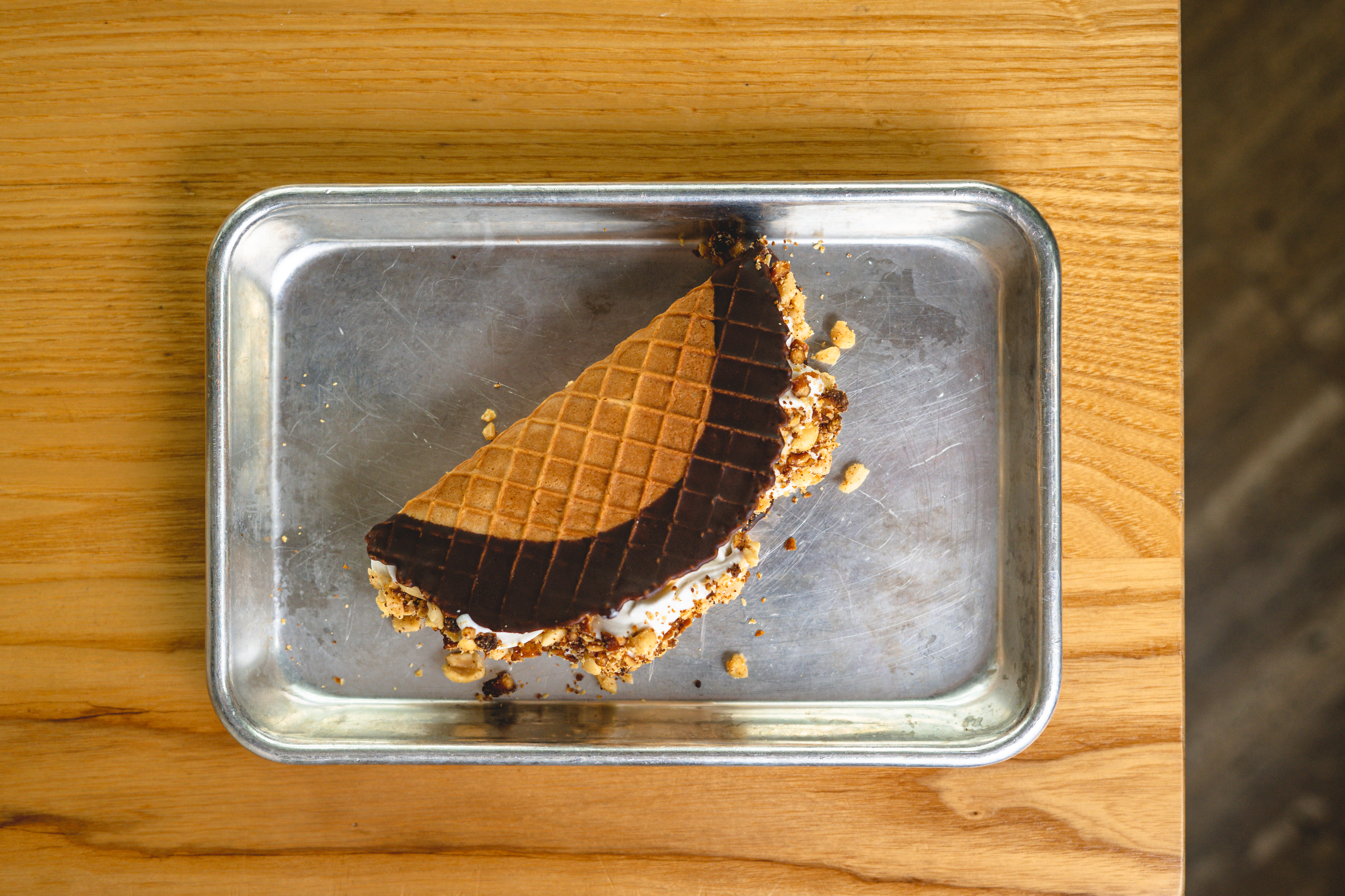 A frozen ice cream treat, a Choco Taco, on a metal platter.