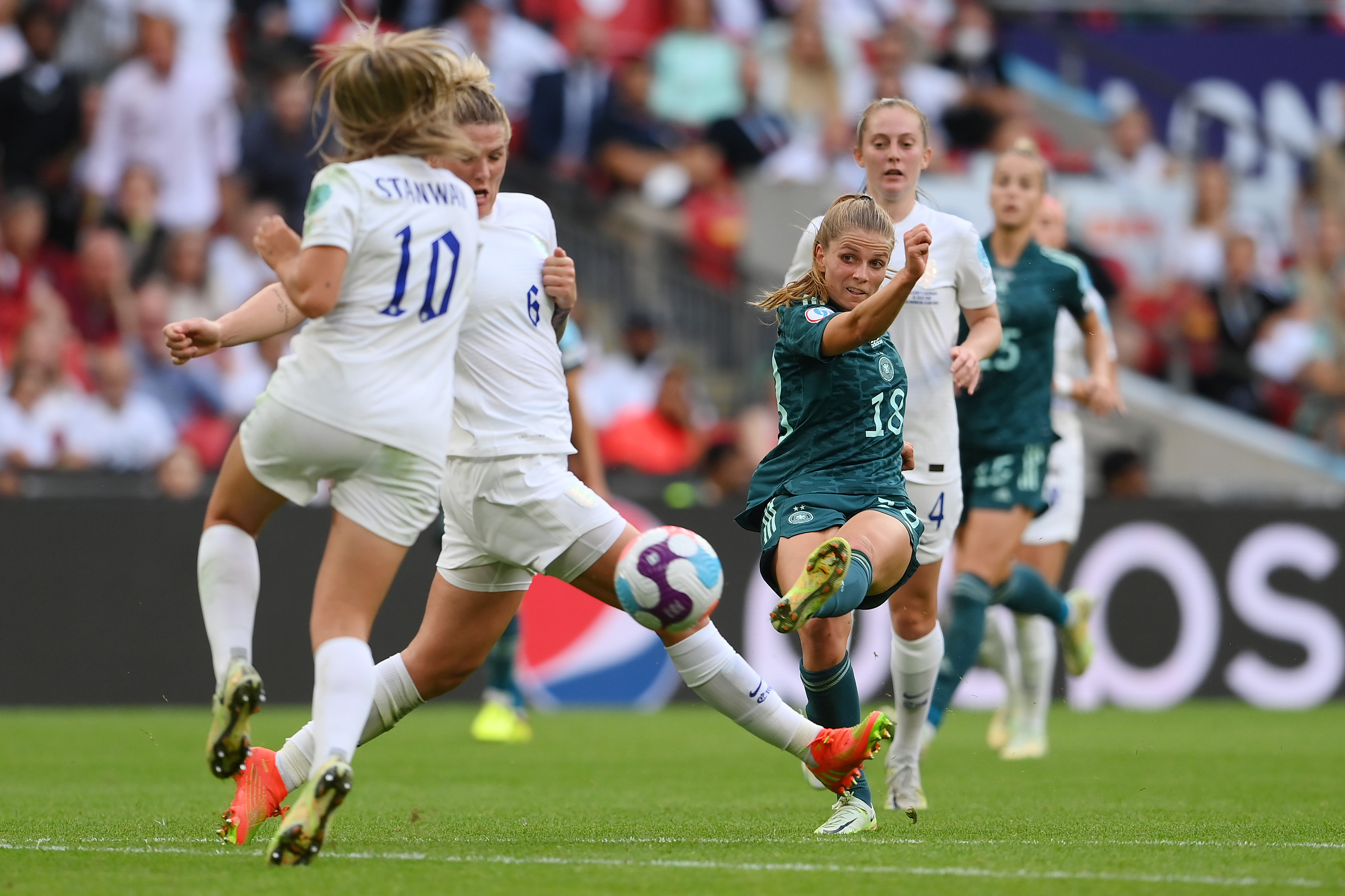 Millie Bright and Georgia Stanway converge to deflect Tabea Waßmuth’s shot as teammates look on.