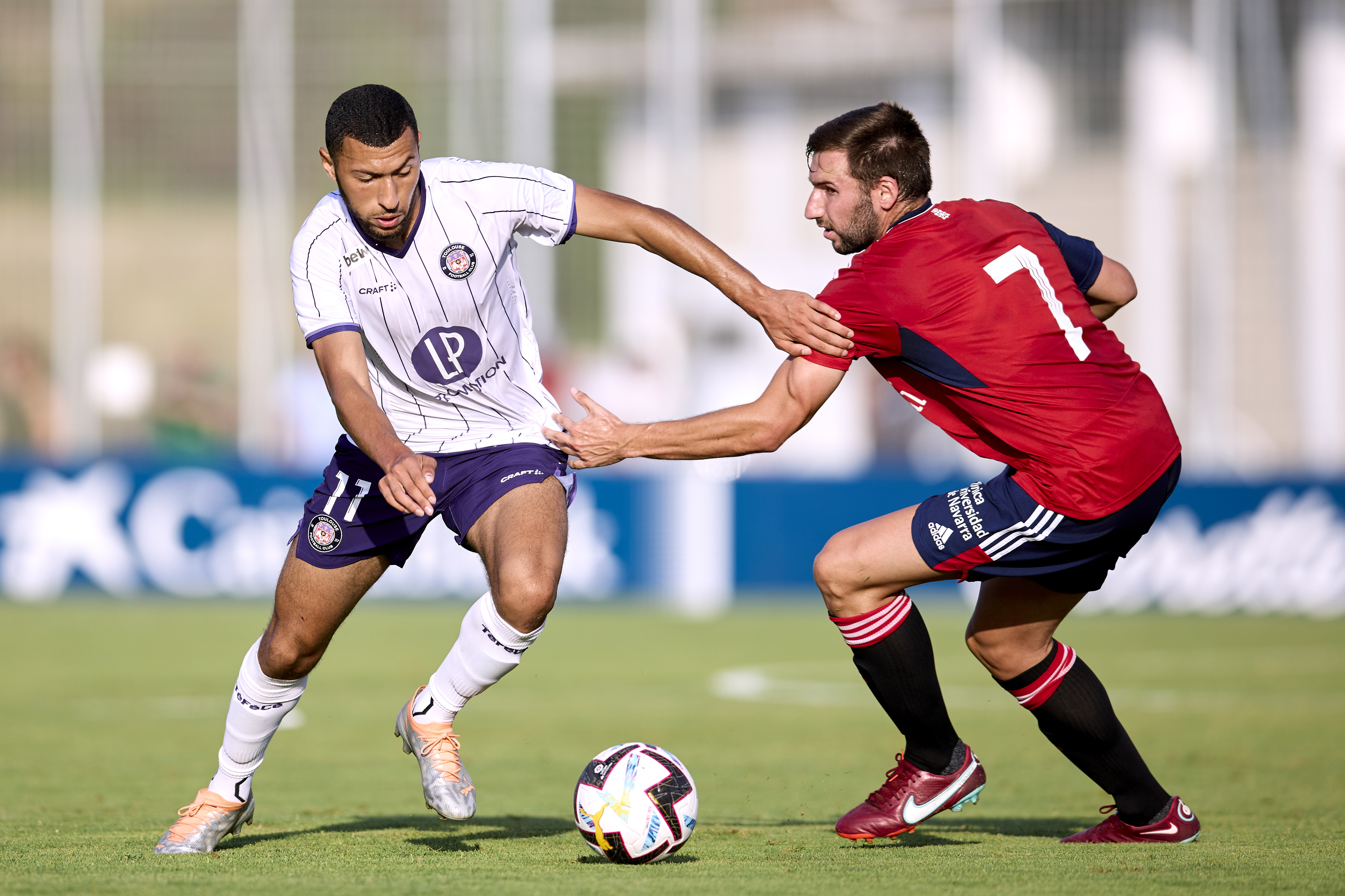 Yanis Begraoui of Toulouse Football Club compete for the ball with Jon Moncayola of CA Osasuna during the pre-season friendly match between CA Osasuna and Toulouse FC at Tajonar Sport Center on July 19, 2022 in Pamplona, Spain.