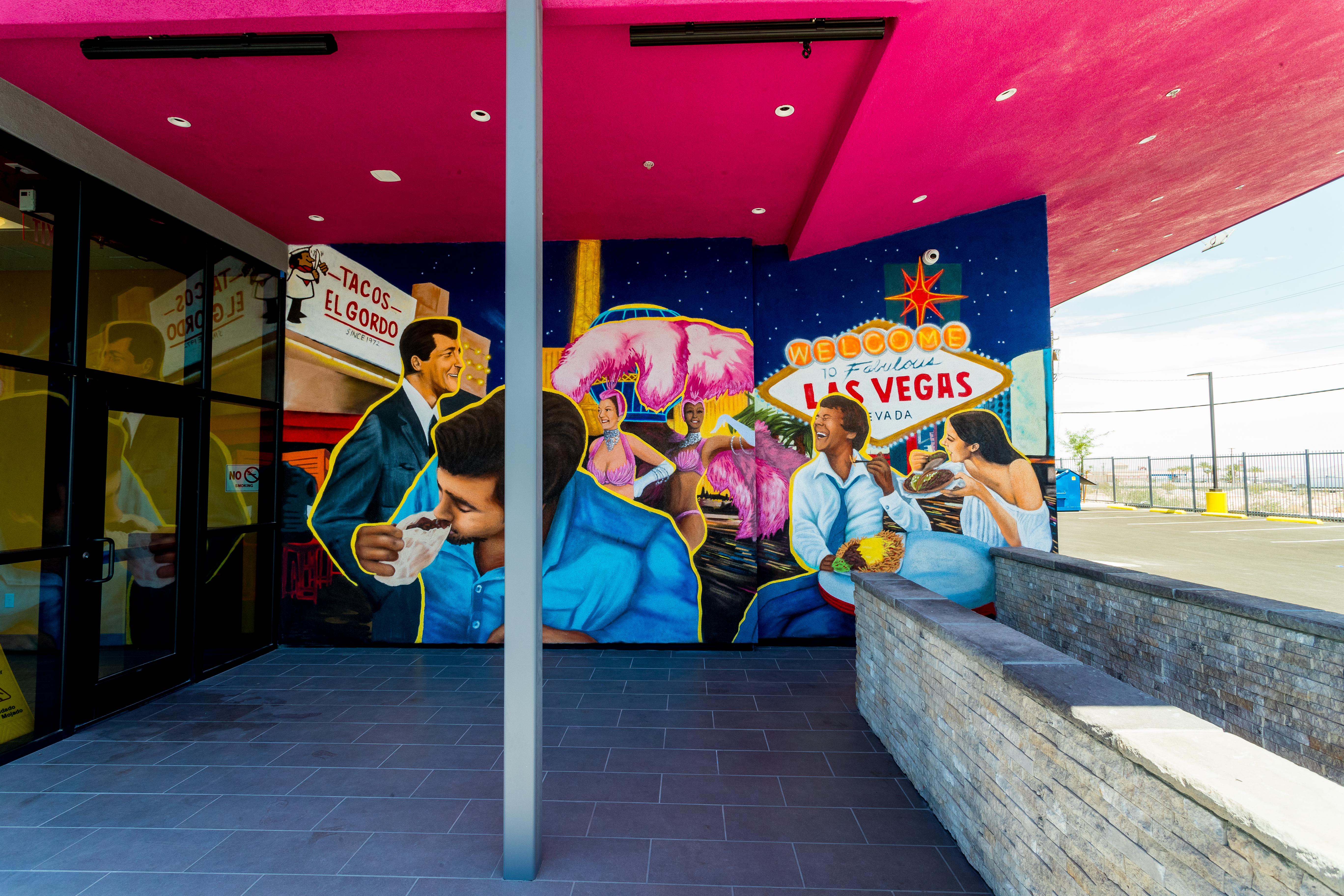 A mural depicting people eating tacos in front of the “Welcome to Fabulous Las Vegas” sign