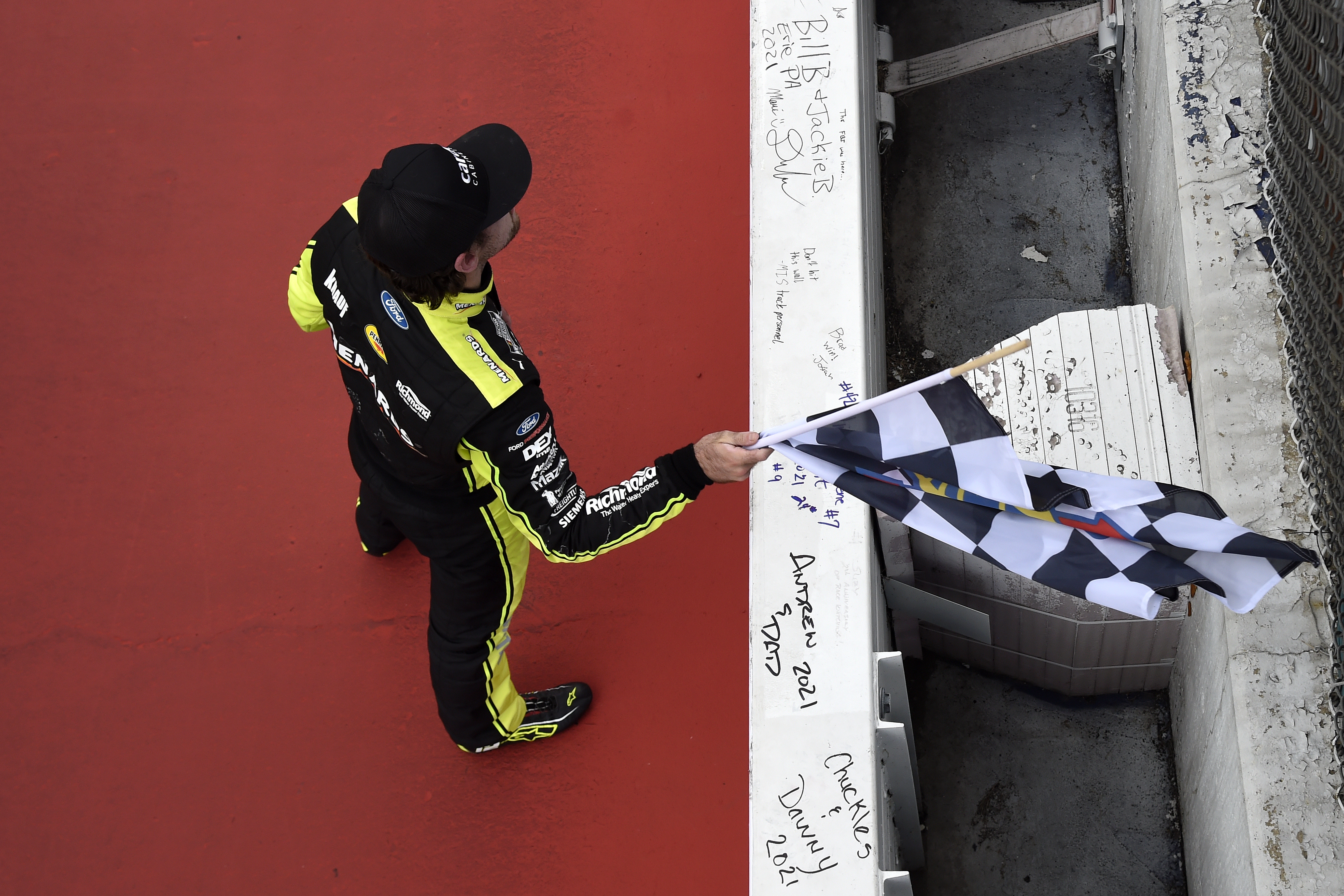 yan Blaney, driver of the #12 Menards/Cardell Cabinetry Ford, celebrates with the checkered flag after winning the NASCAR Cup Series FireKeepers Casino 400 at Michigan International Speedway on August 22, 2021 in Brooklyn, Michigan.