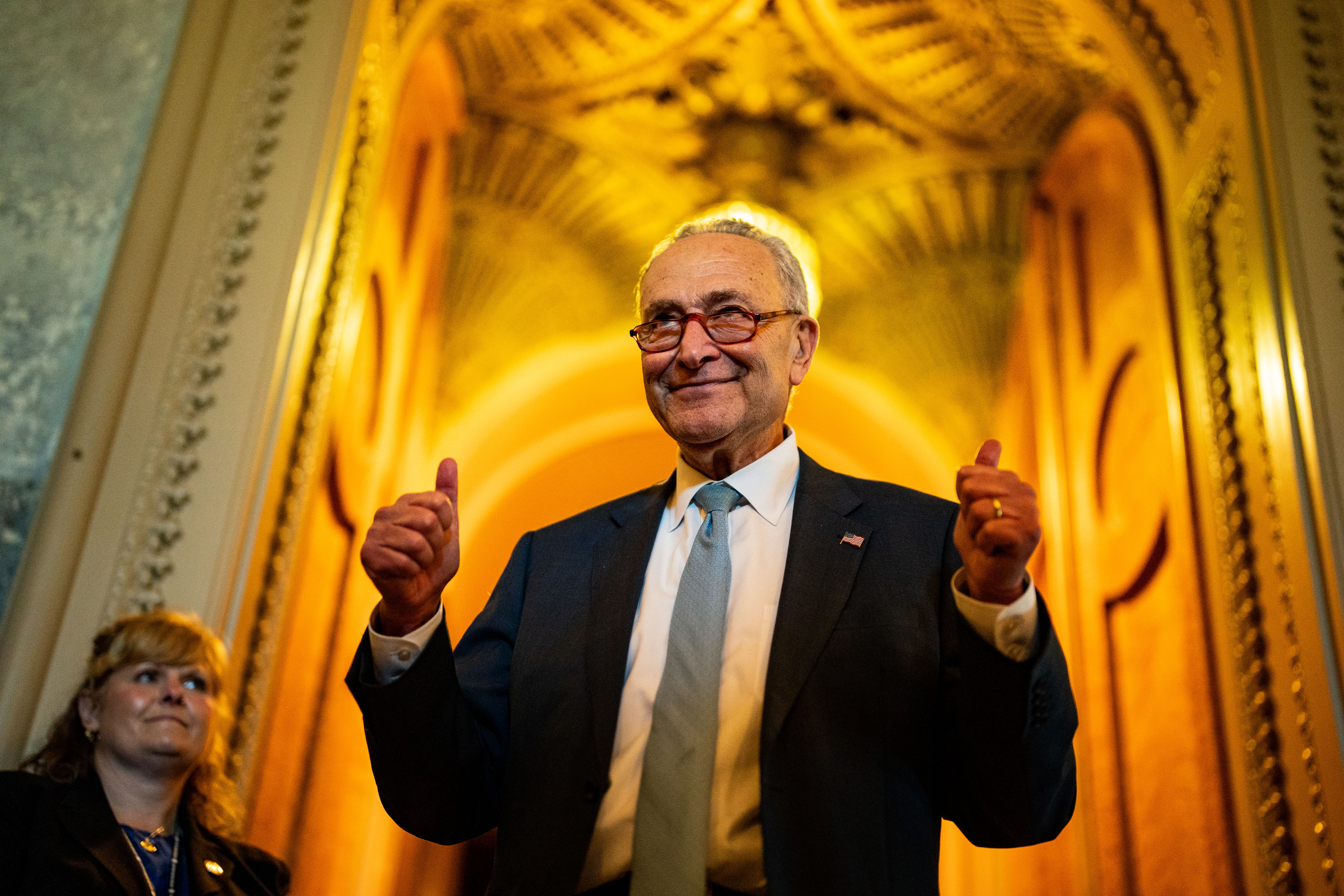 Senate Majority Leader Chuck Schumer walks out of the Senate Chamber with his thumbs up on August 7, 2022. 