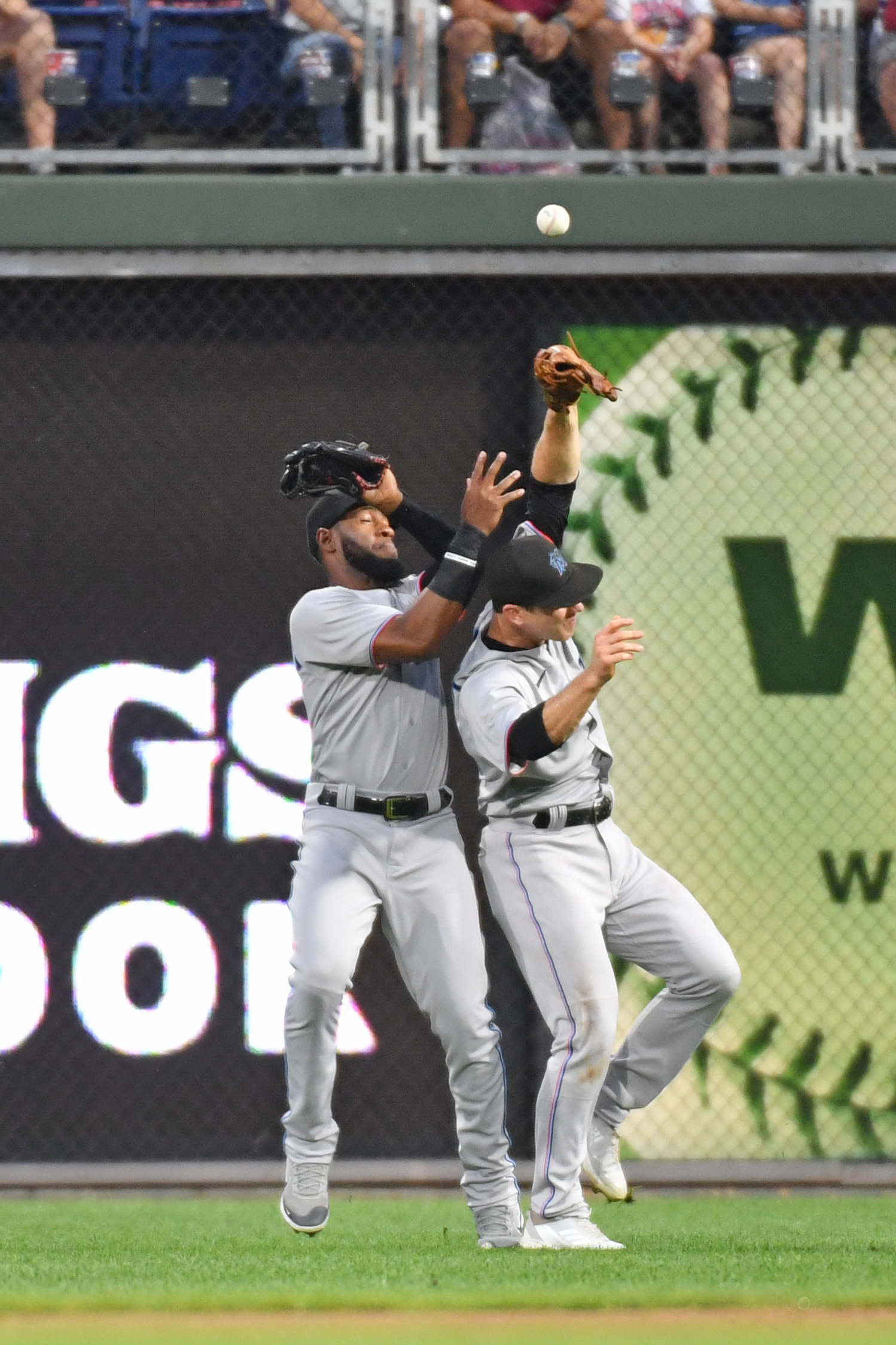 Miami Marlins left fielder Bryan De La Cruz (14) and second baseman Joey Wendle (18) collide while trying to catch a fly ball against the Philadelphia Phillies during the first inning at Citizens Bank Park.