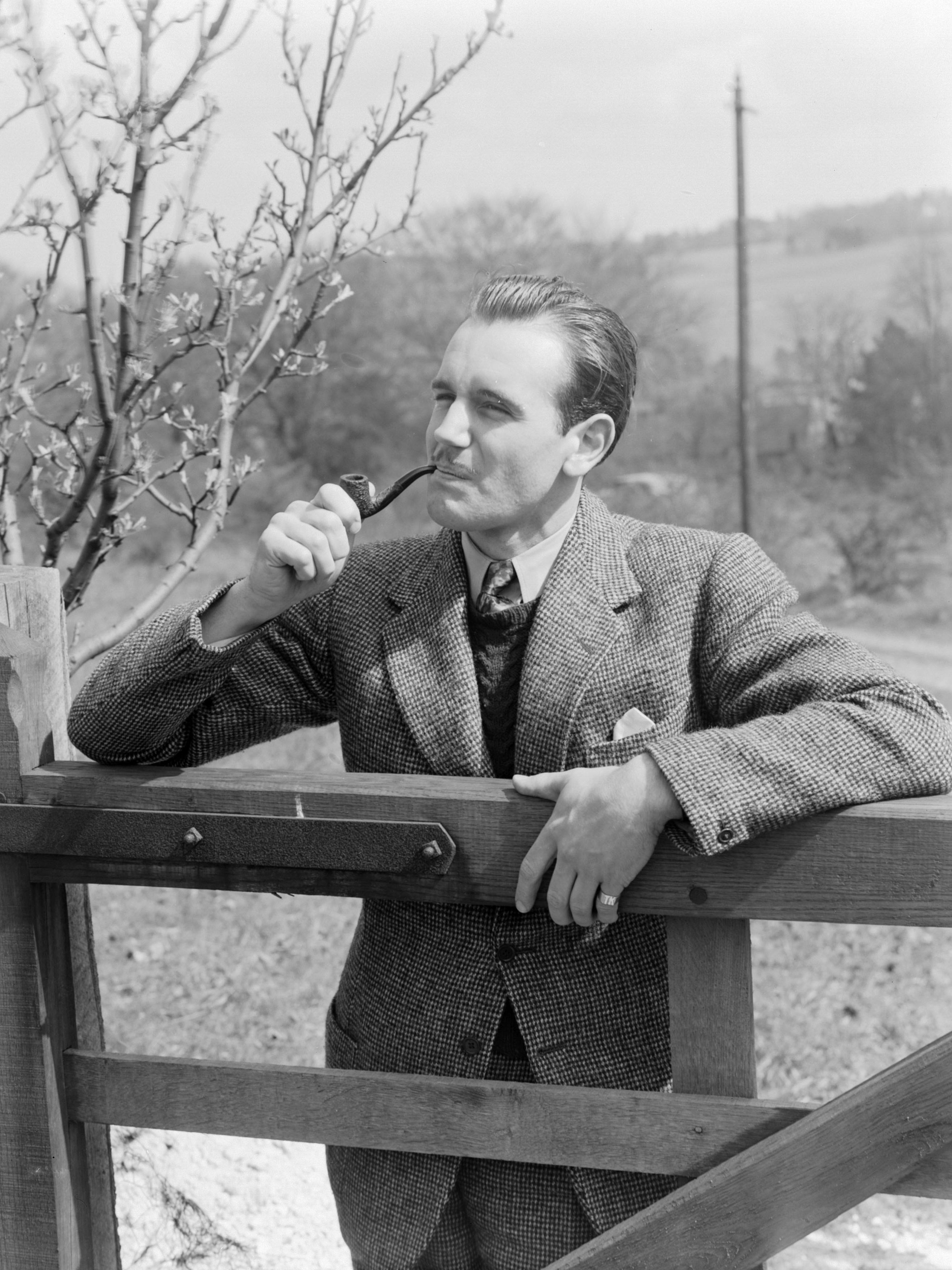 Man at a gate smoking a pipe, 1951.