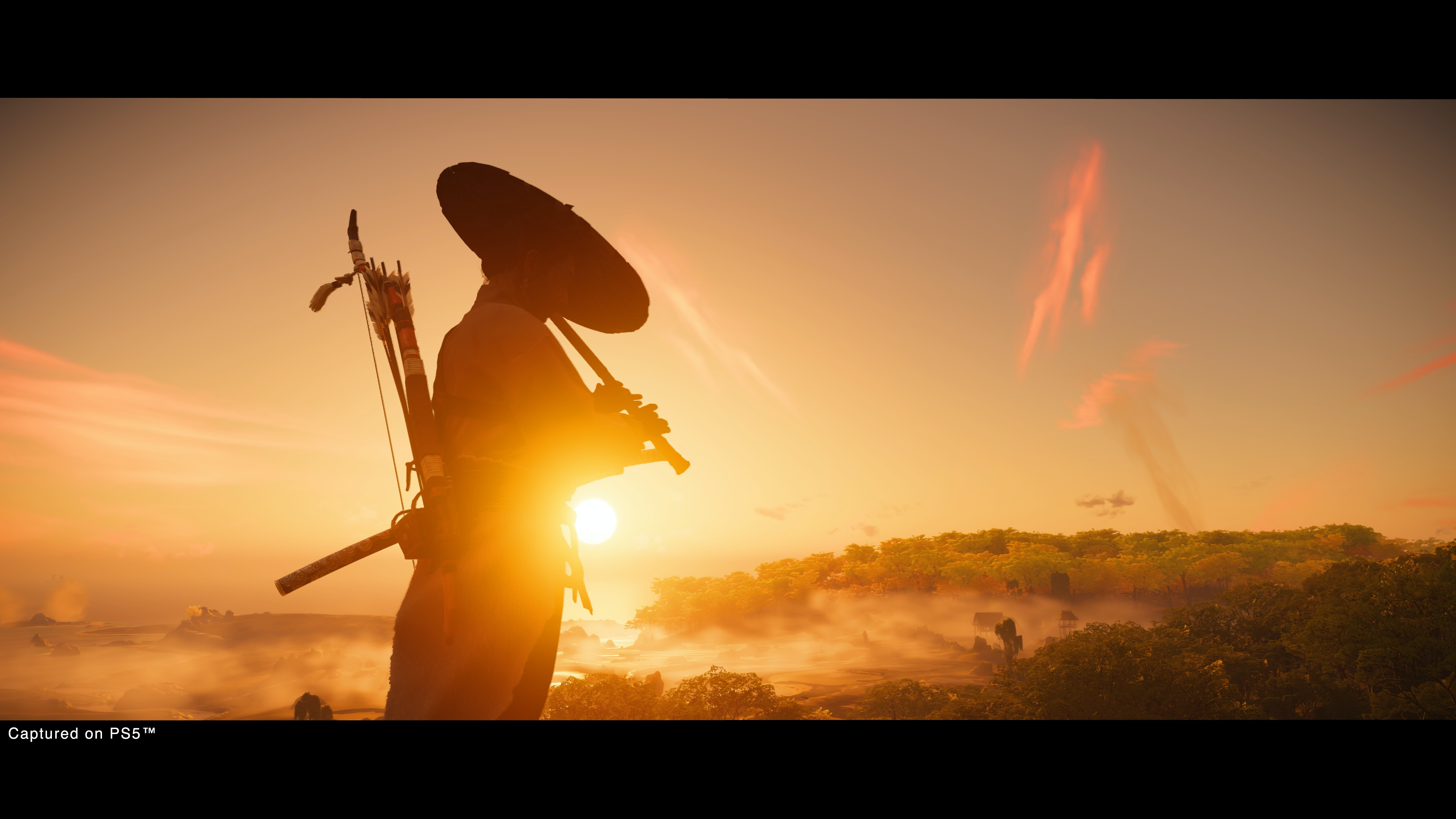 A samurai plays the flute, silhouetted against a sunset