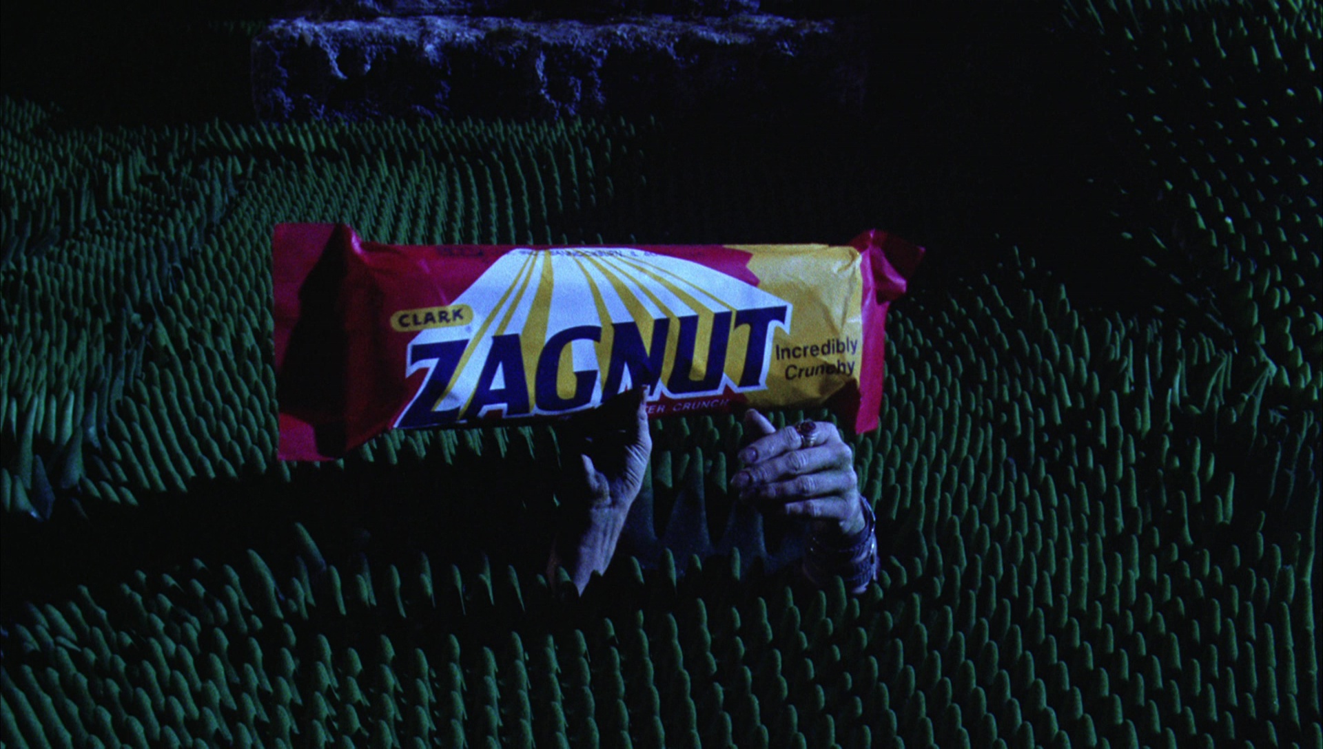 Beetlejuice, miniaturized, lures a large housefly with a Zagnut candy bar