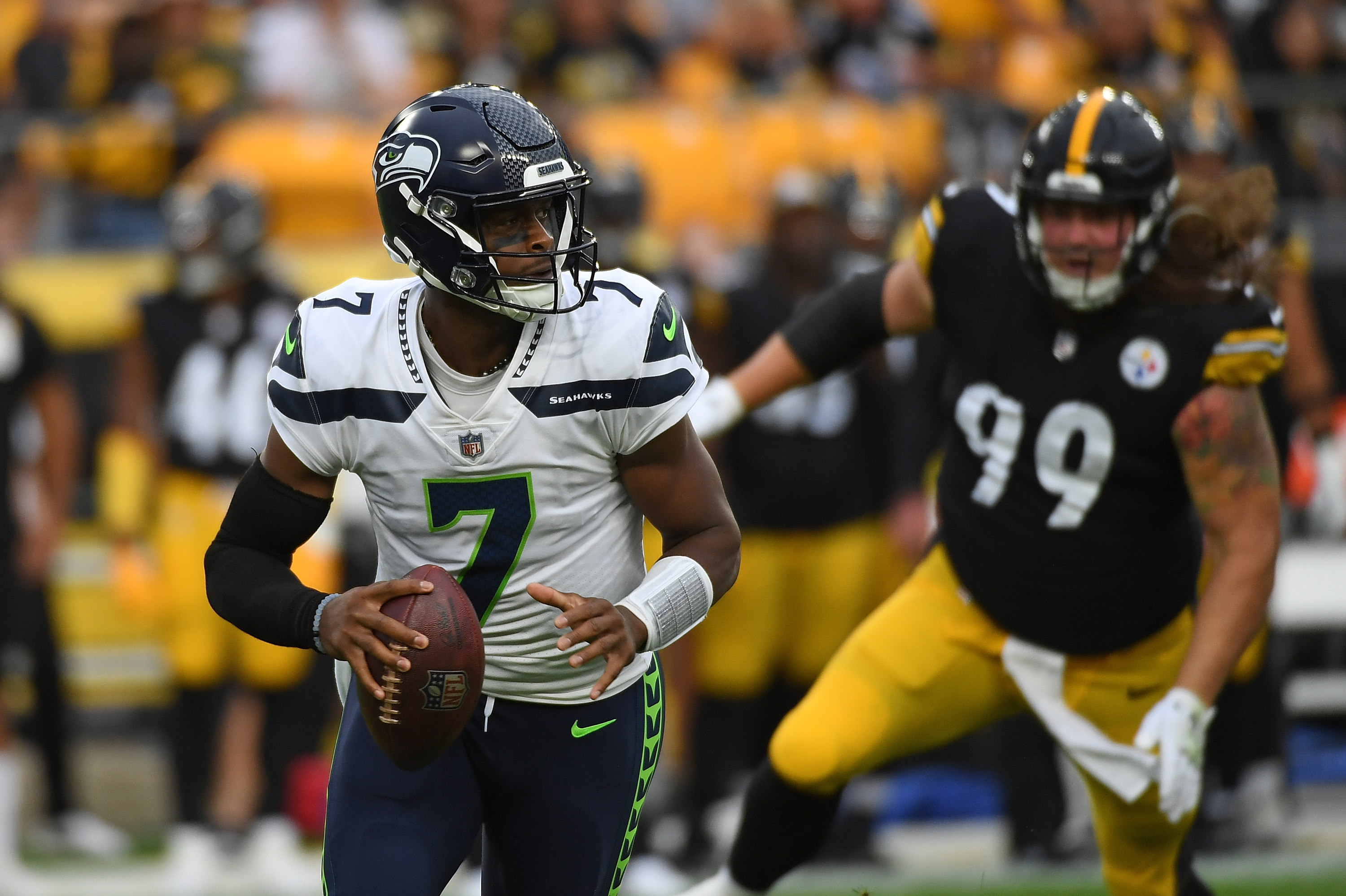 Geno Smith #7 of the Seattle Seahawks scrambles out of the pocket under pressure from Henry Mondeaux #99 of the Pittsburgh Steelers in the first quarter during a preseason game at Acrisure Stadium on August 13, 2022 in Pittsburgh, Pennsylvania.