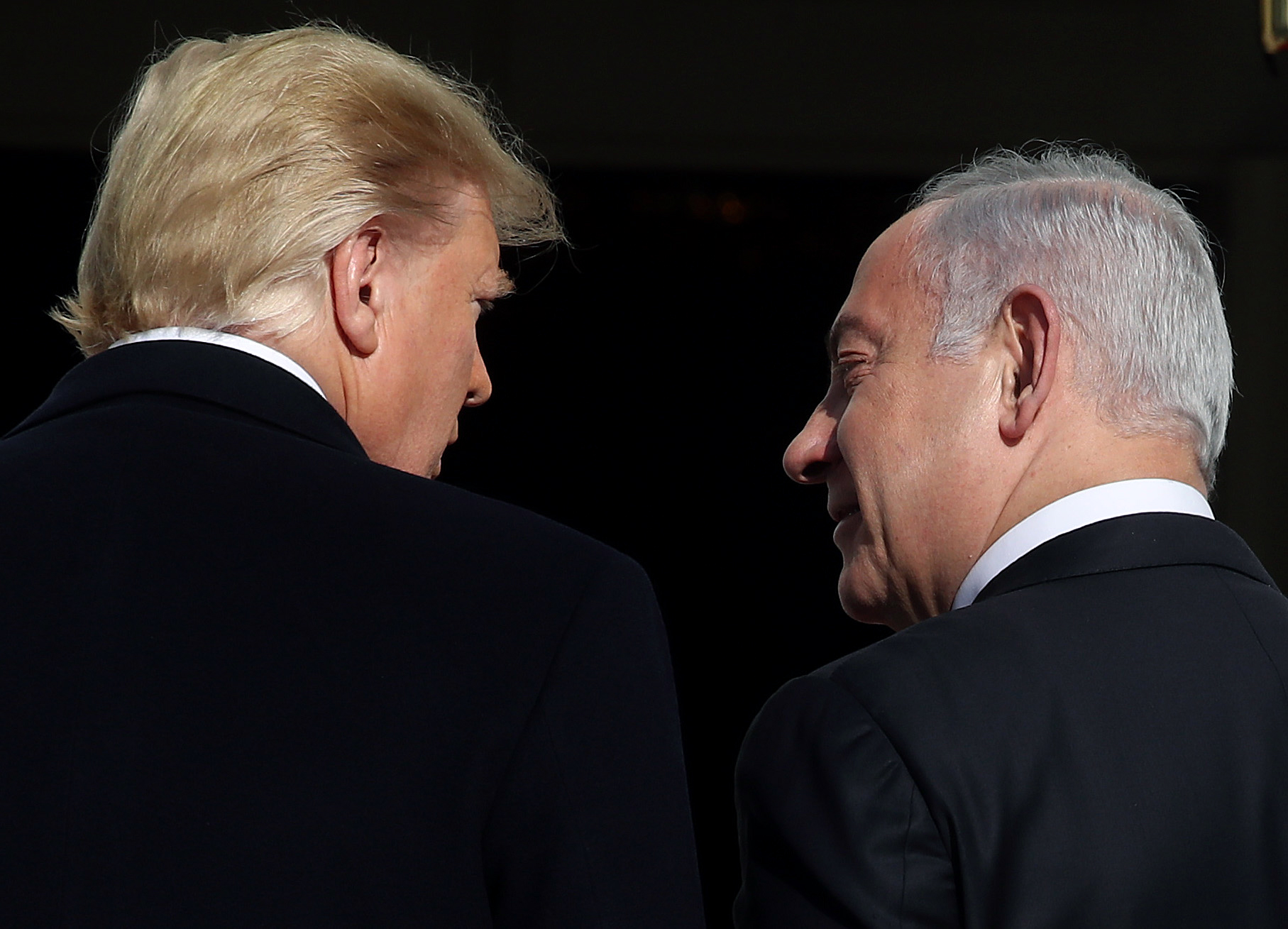 Trump and Netanyahu, speaking to one another while walking away from the camera.