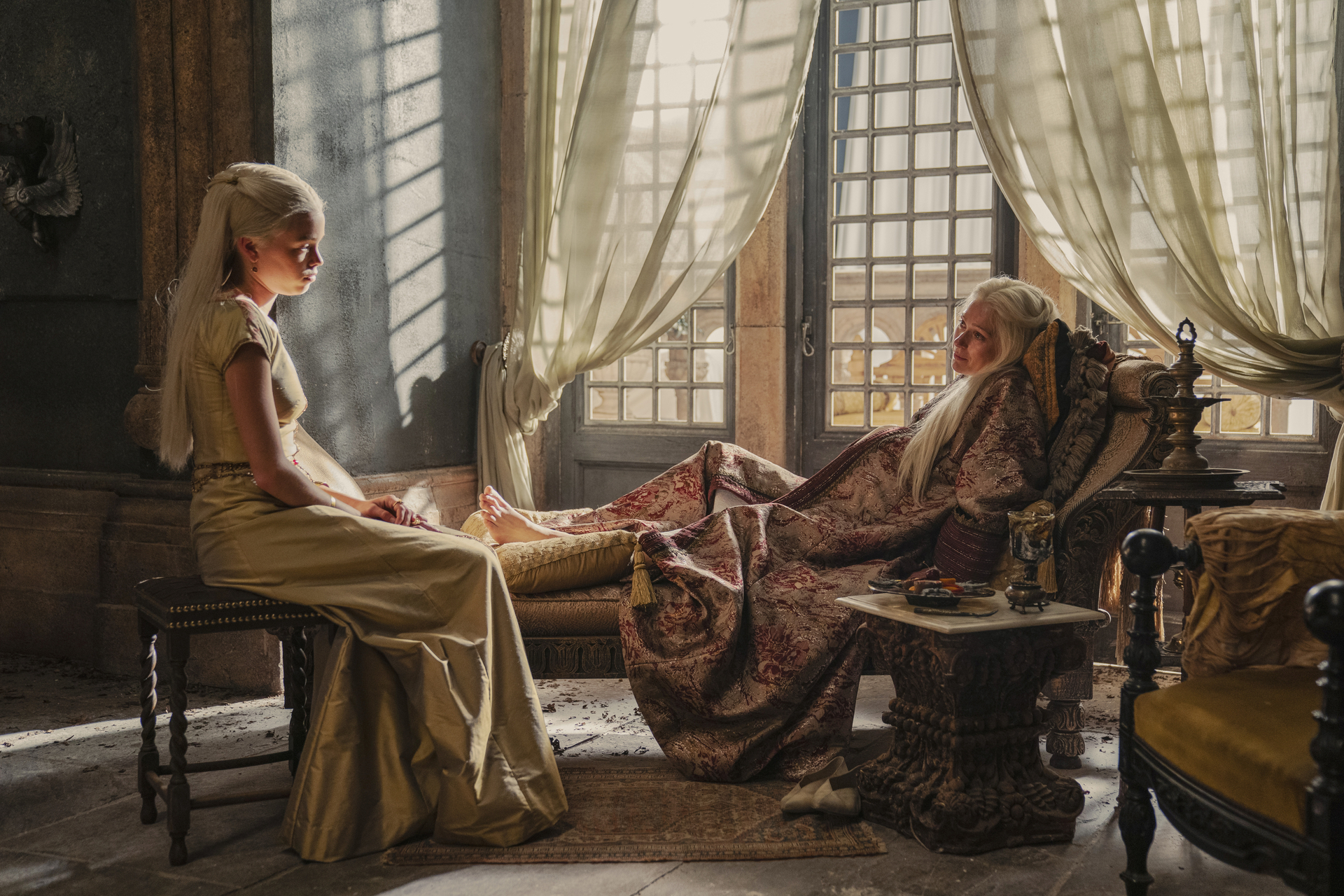 Rhaenyra Targaryen sitting and talking to her mother, who is reclining and very pregnant