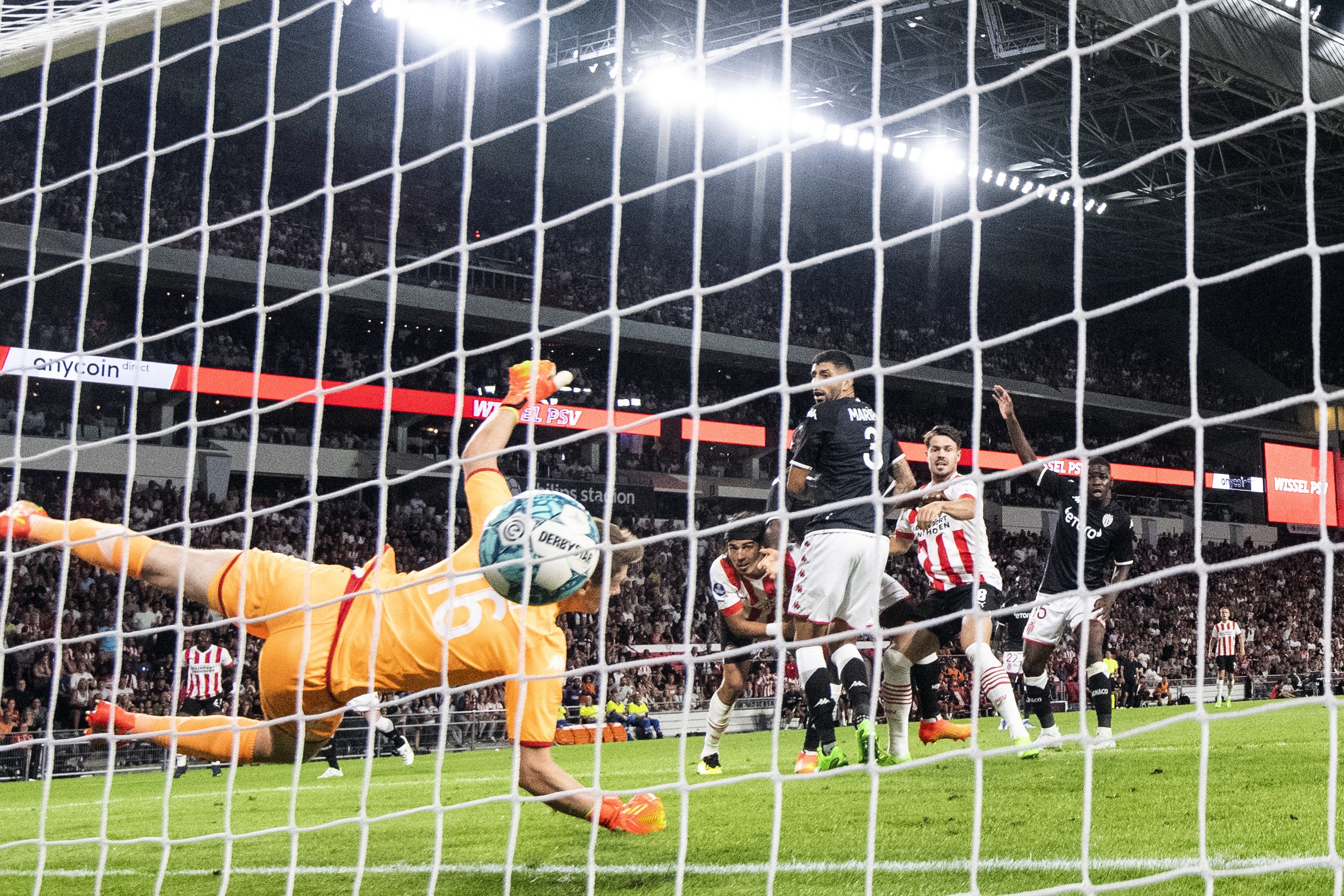The ball flies into the back of the net as Alexander Nübel dives in front of it. Erick Gutierrez, the scorer, looks on.