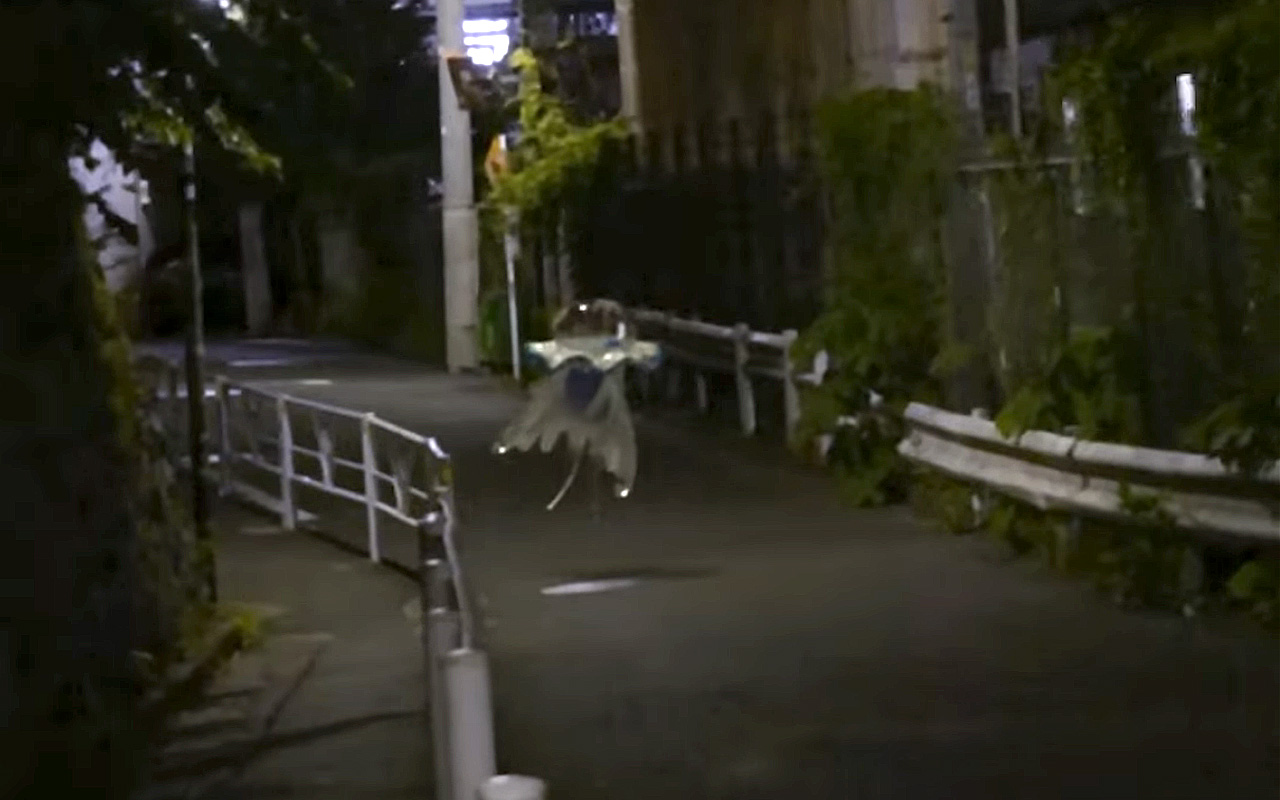 A still of found footage-style video of Pokémon Ultra Beast Nihilego on the streets of Tokyo at night