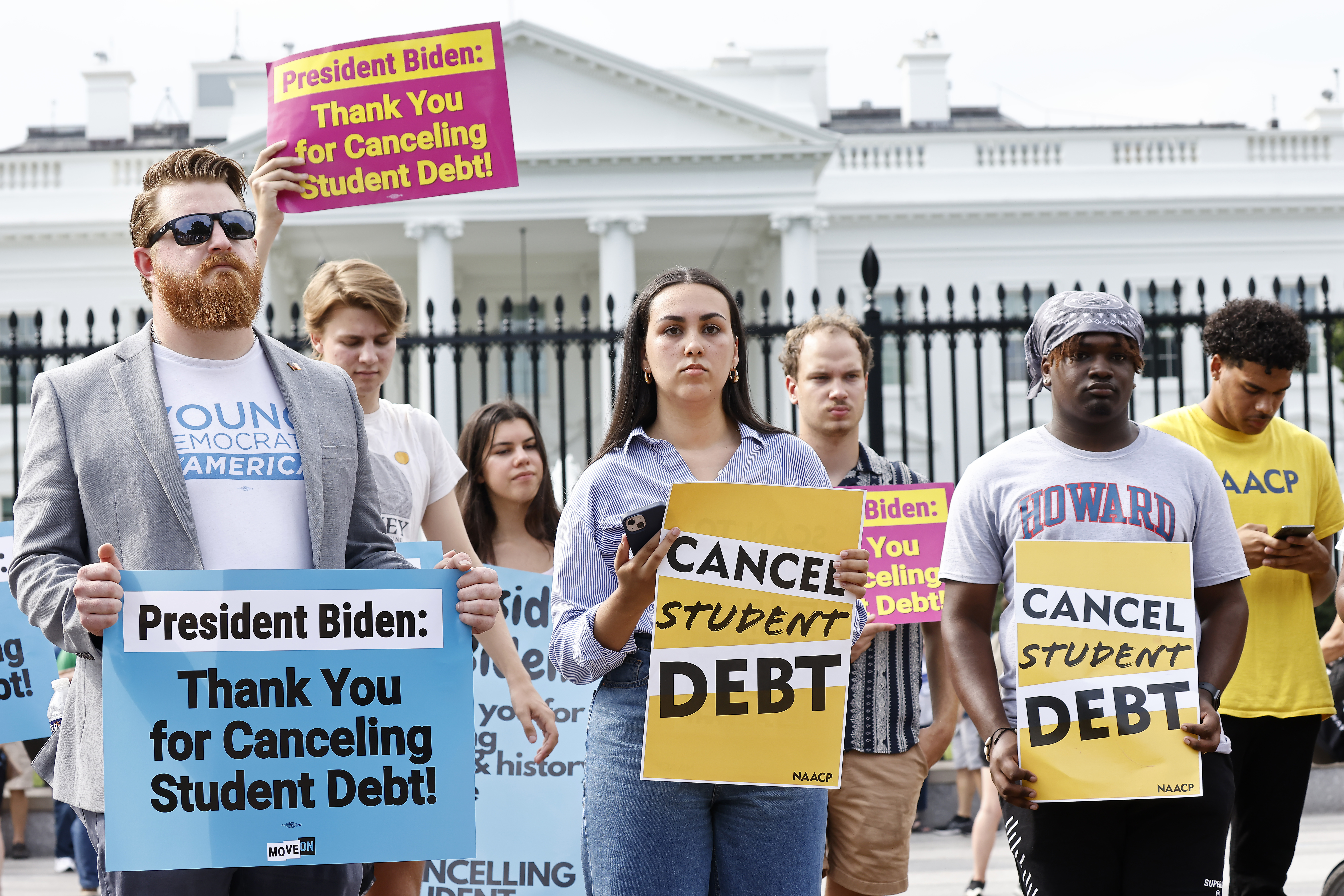 Protesters in front of the White House in Washington, DC, carry signs that read, “Cancel student debt.”