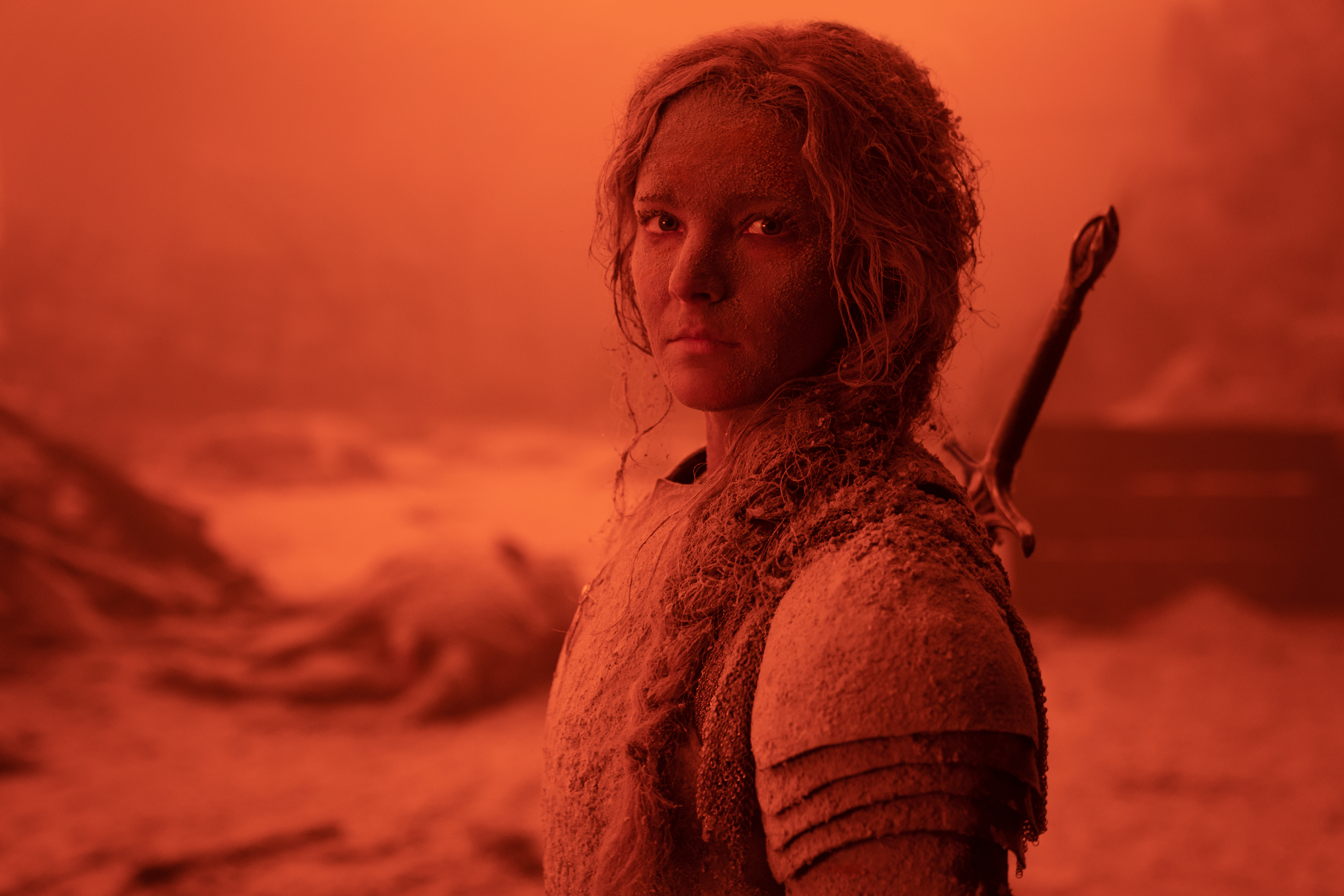 Galadriel (Morfydd Clark) stands in defiance bathed in red light in Lord of the Rings: The Rings of Power