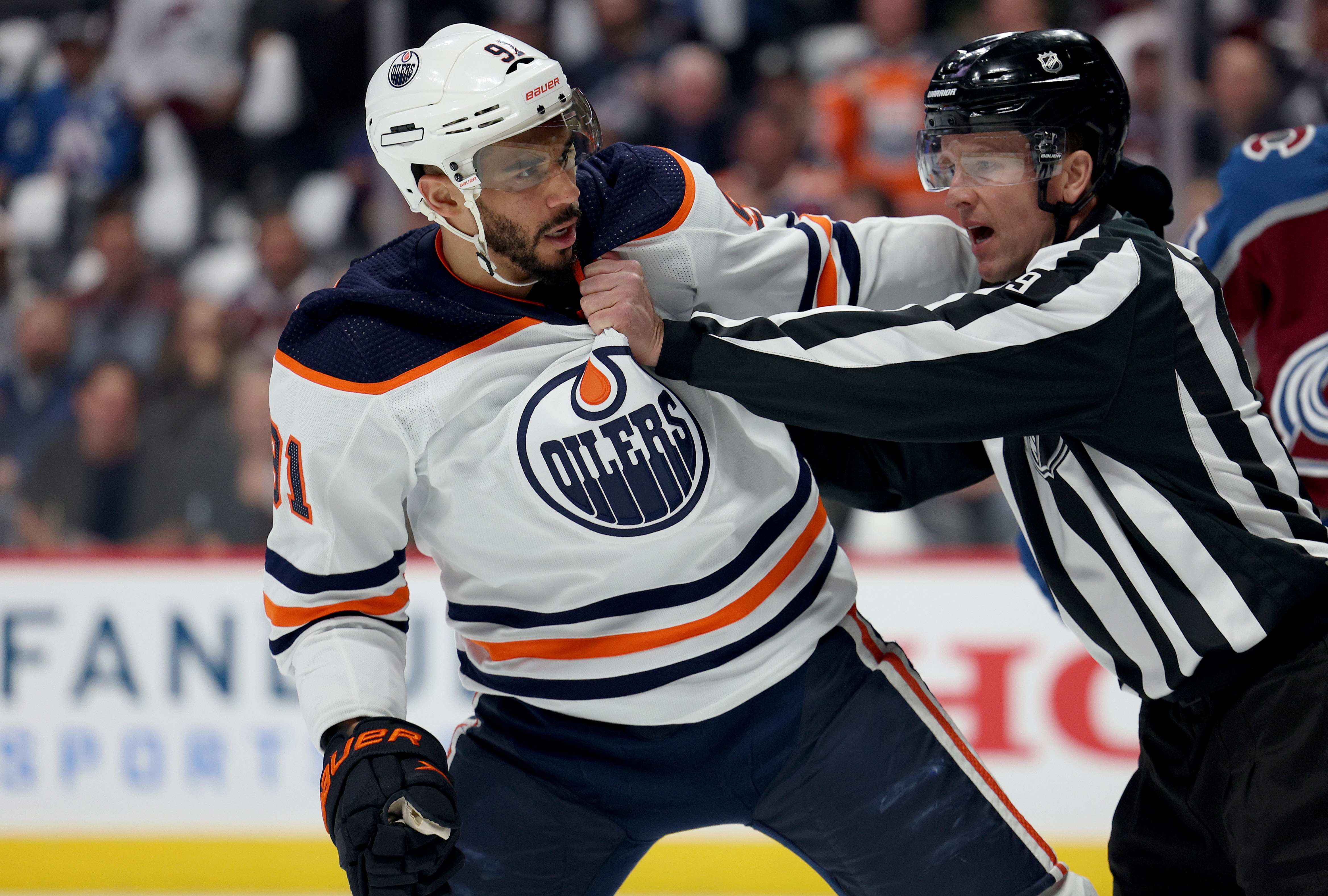 Evander Kane #91 of the Edmonton Oilers is held back by referee Dan O’Rourke #9 against the Colorado Avalanche during the first period Game Two of the Western Conference Final of the 2022 Stanley Cup Playoffs at Ball Arena on June 02, 2022 in Denver, Colorado.