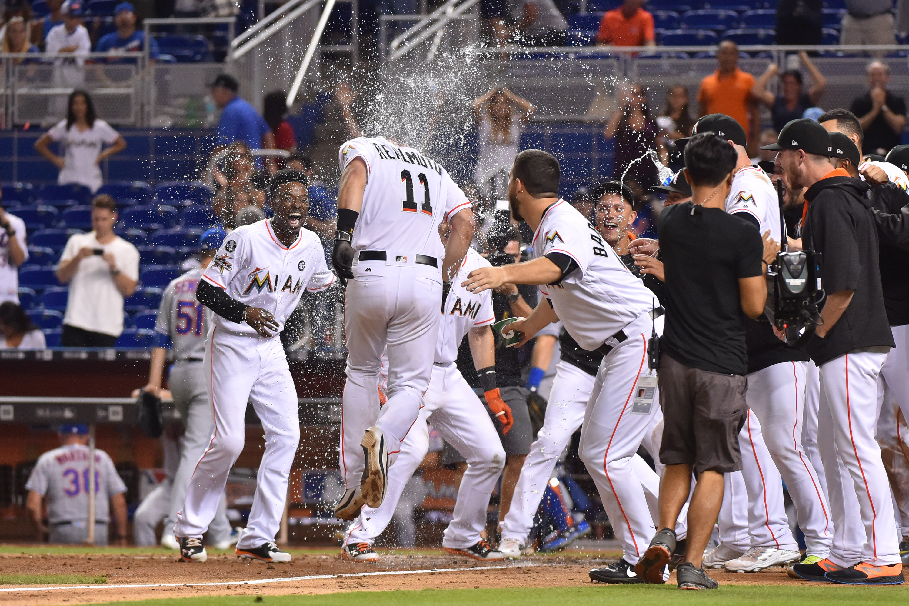 J.T. Realmuto #11 of the Miami Marlins is congratulated by teammates after hitting a walk off home run in the tenth inning against the New York Mets at Marlins Park on September 19, 2017 in Miami, Florida.