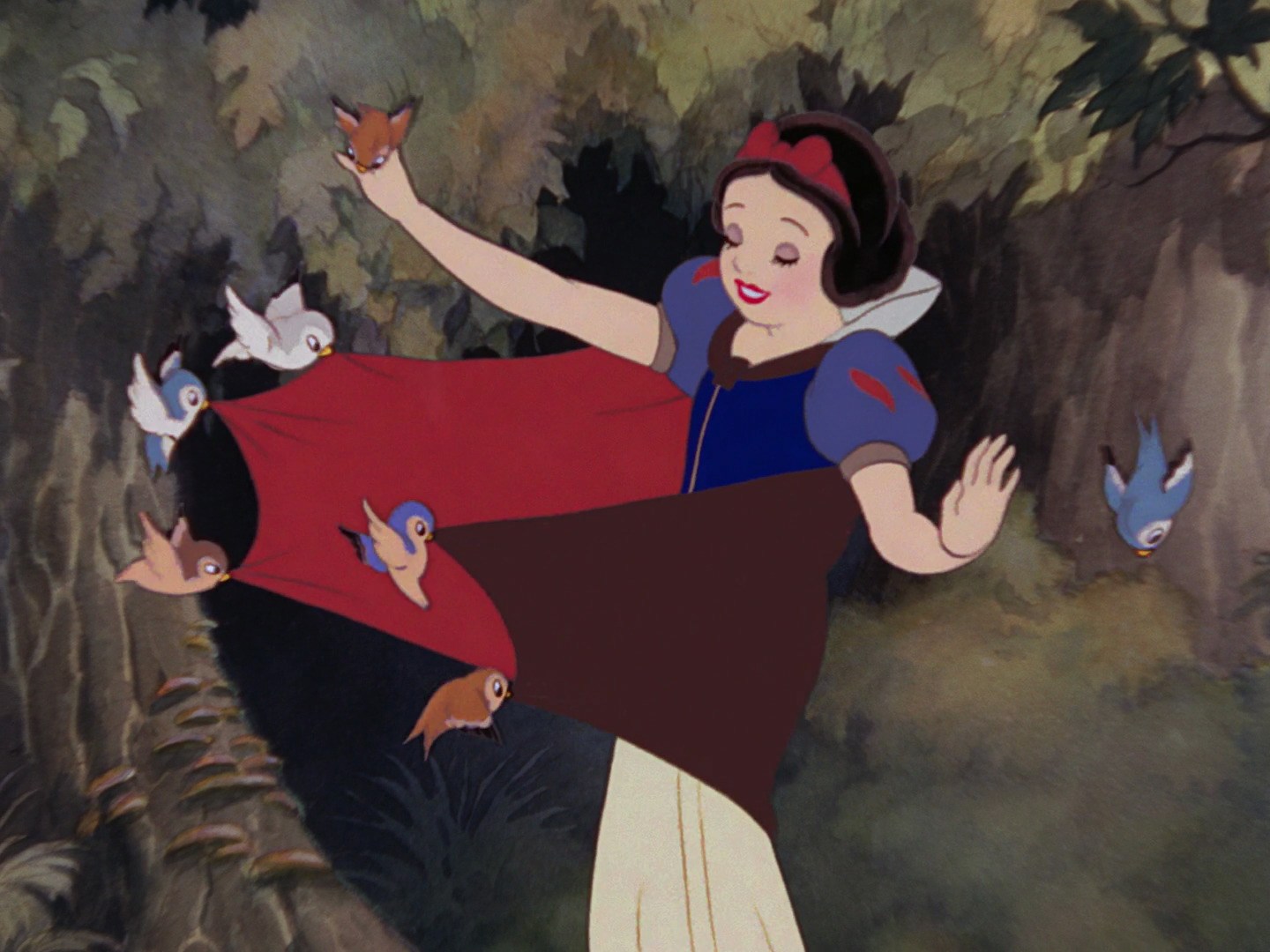 Snow White in Disney’s original animated Snow White and the Seven Dwarfs. She is in the forest and five small birds are pulling at her cape.