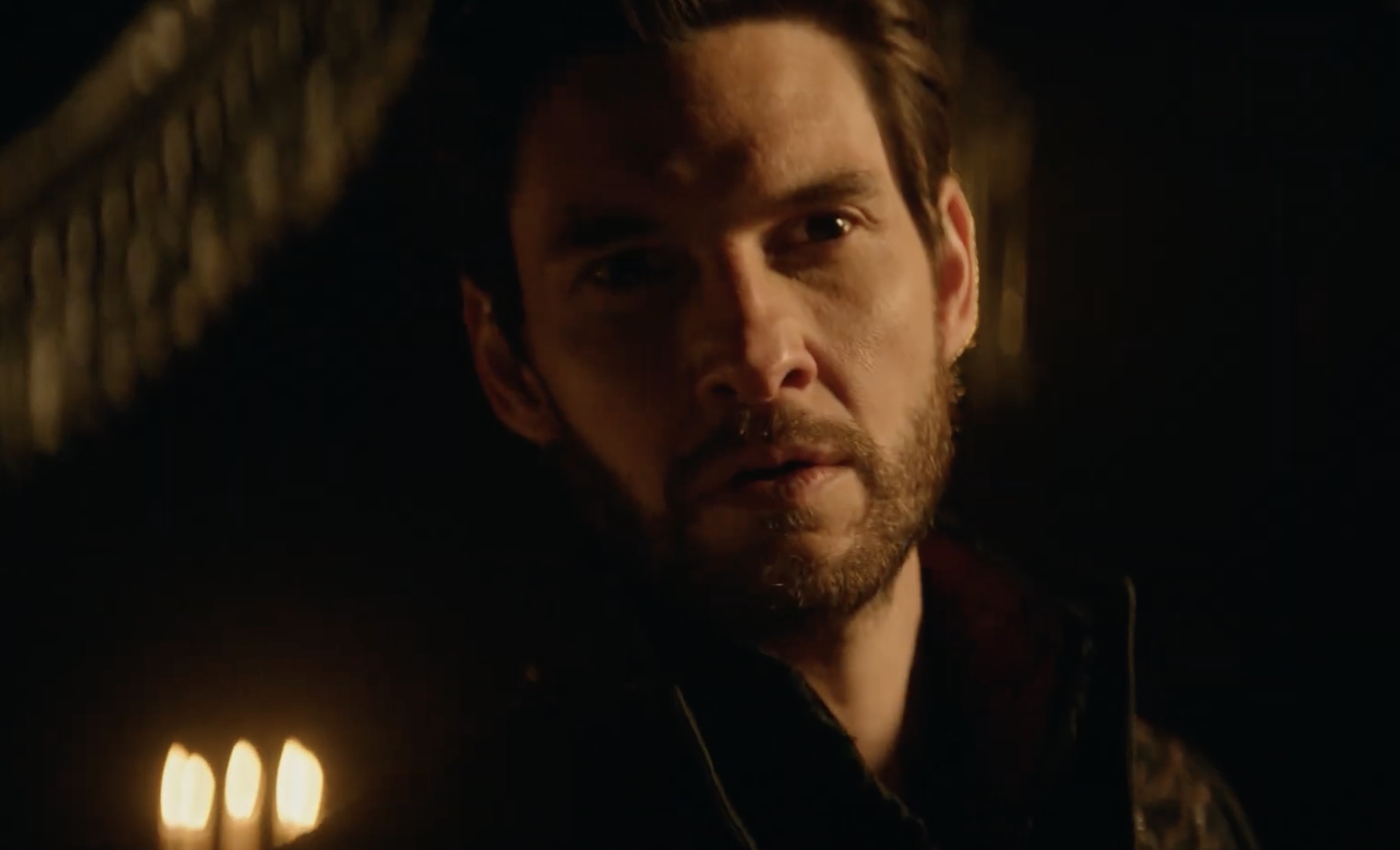 Ben Barnes doing that sexy mouth slightly open gaze things surrounded by candles in a dark room in Shadow and Bone season 2