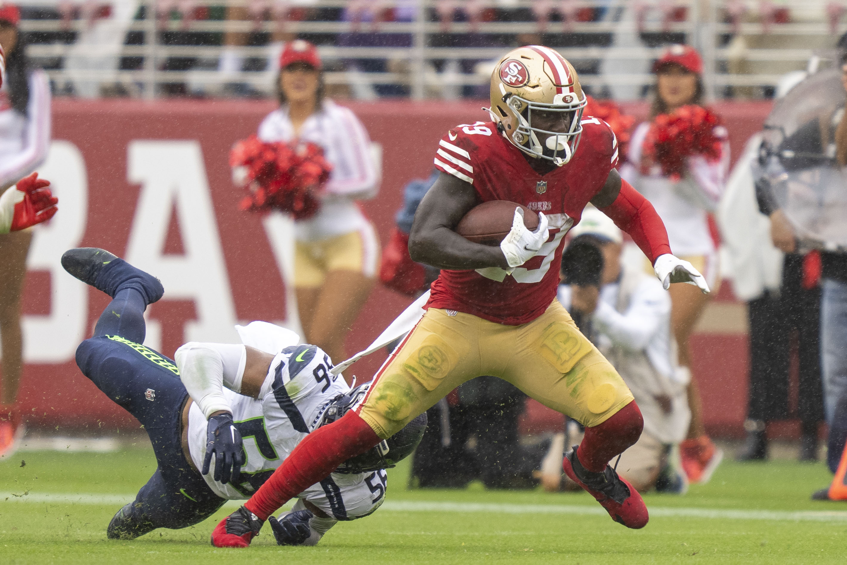 San Francisco 49ers wide receiver Deebo Samuel (19) runs with the football past Seattle Seahawks linebacker Jordyn Brooks (56) during the third quarter at Levi’s Stadium.