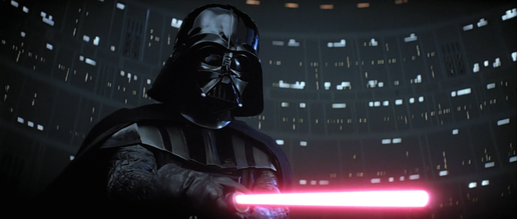 Darth Vader points his red lightsaber at Luke Skywalker during their fight in Cloud City in The Empire Strikes Back