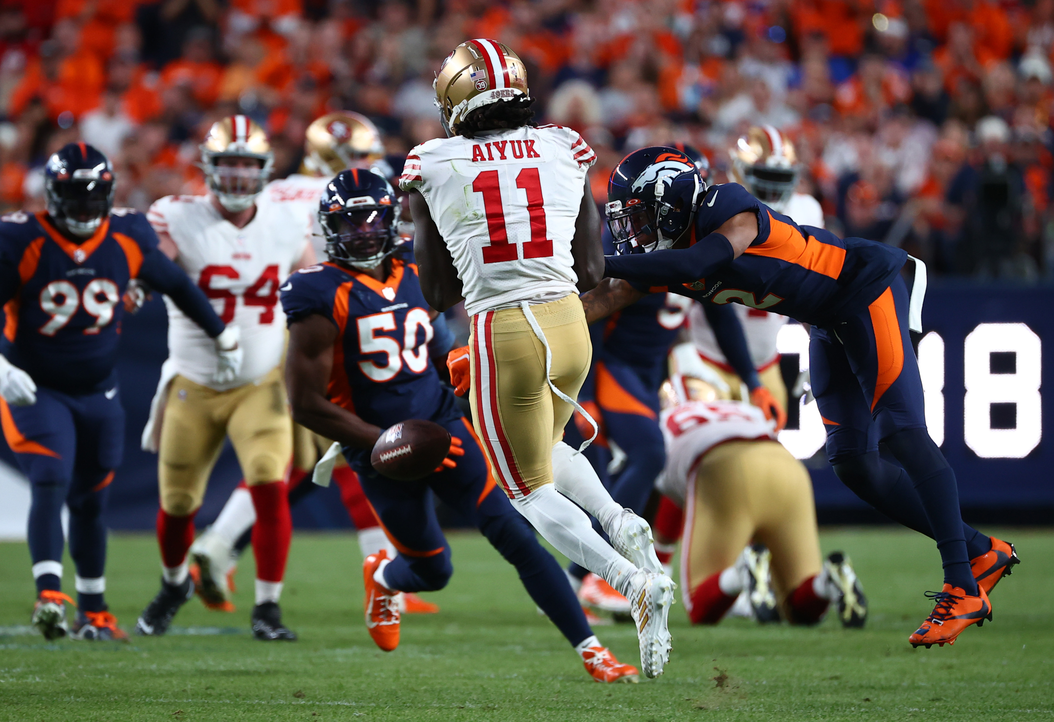 Pat Surtain II #2 of the Denver Broncos punches the ball away from Brandon Aiyuk #11 of the San Francisco 49ers during the first half of a game at Empower Field At Mile High on September 25, 2022 in Denver, Colorado.