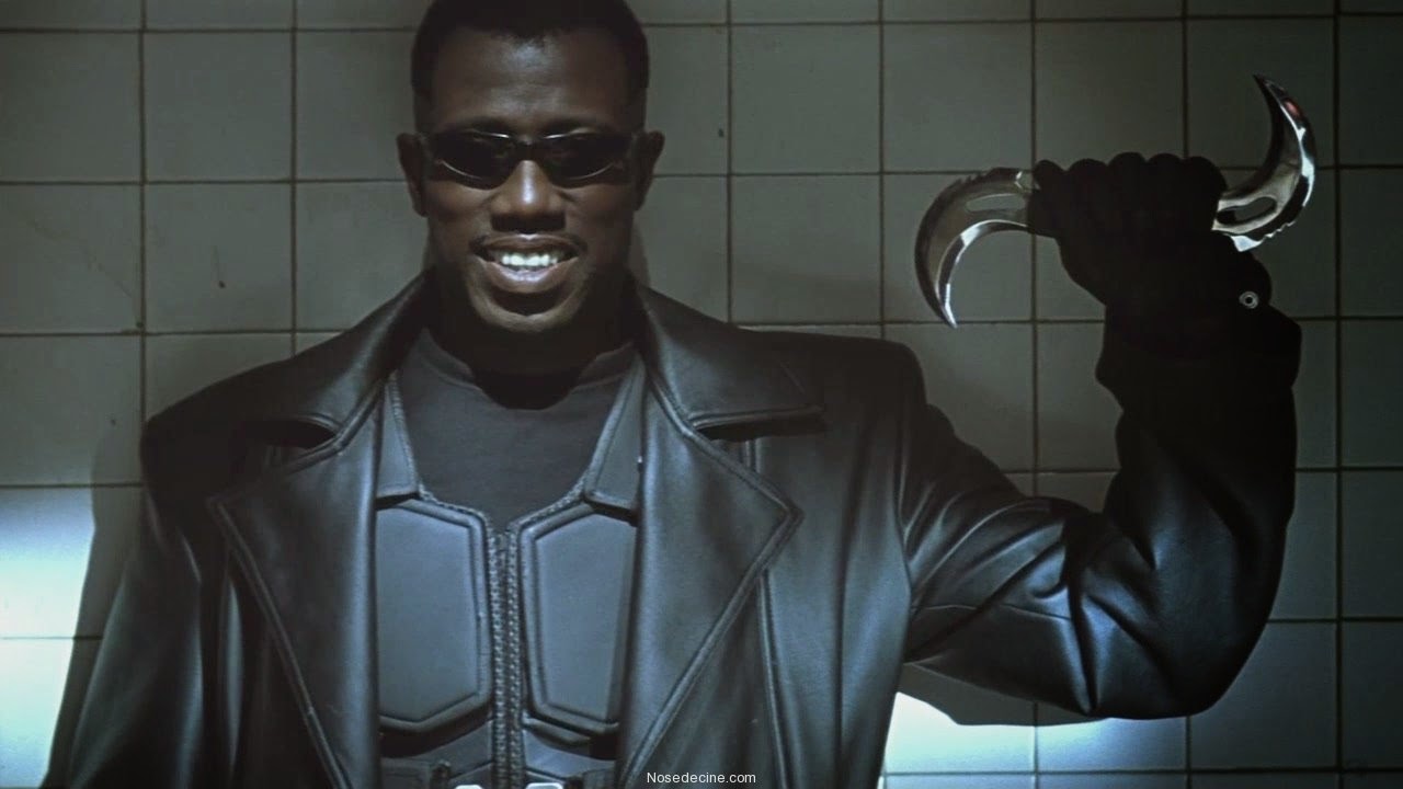 Wesley Snipes as Blade holding a double-bladed boomerang and smiling in Blade (1998)
