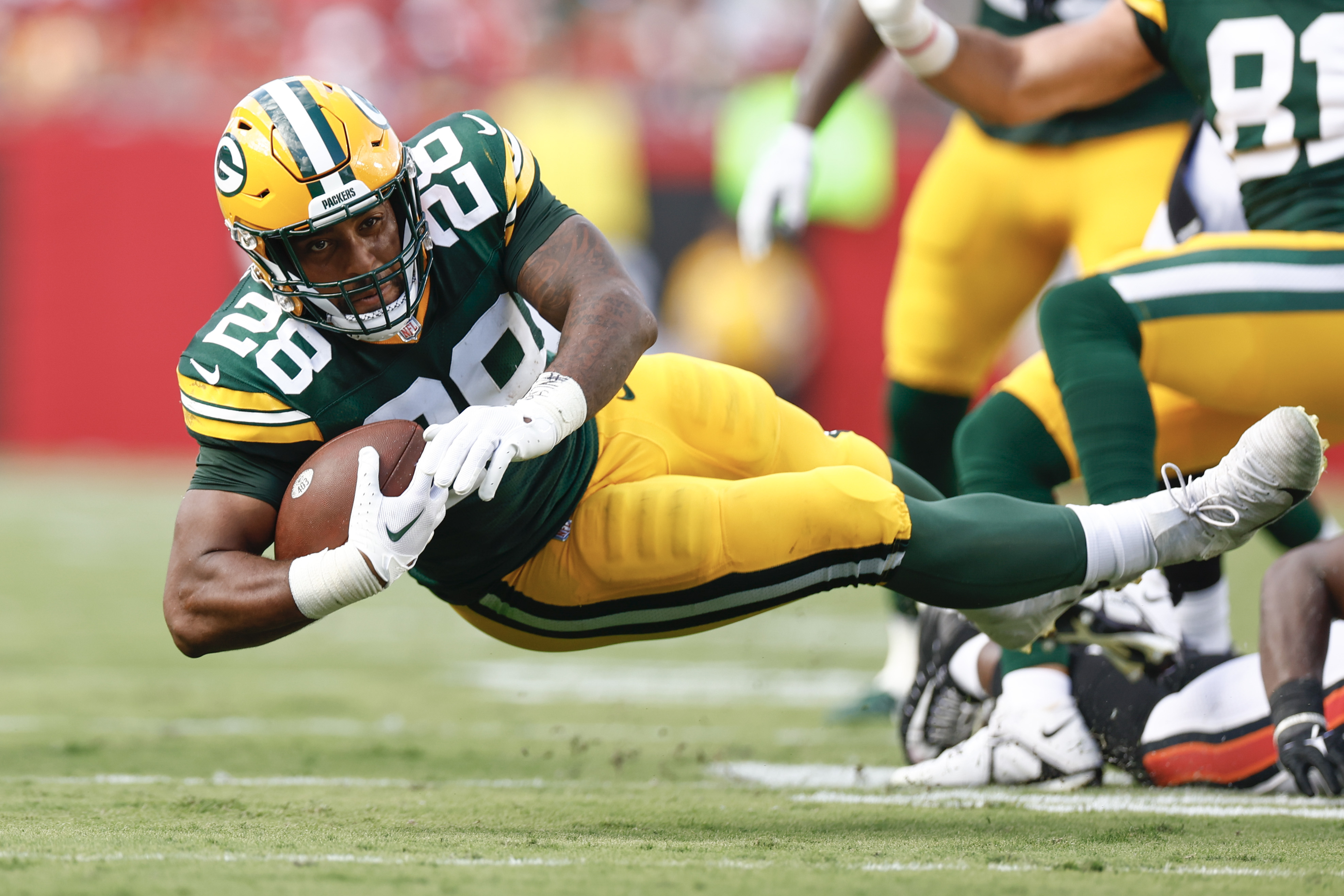 AJ Dillon #28 of the Green Bay Packers runs with the ball against the Tampa Bay Buccaneers during the second quarter at Raymond James Stadium on September 25, 2022 in Tampa, Florida.