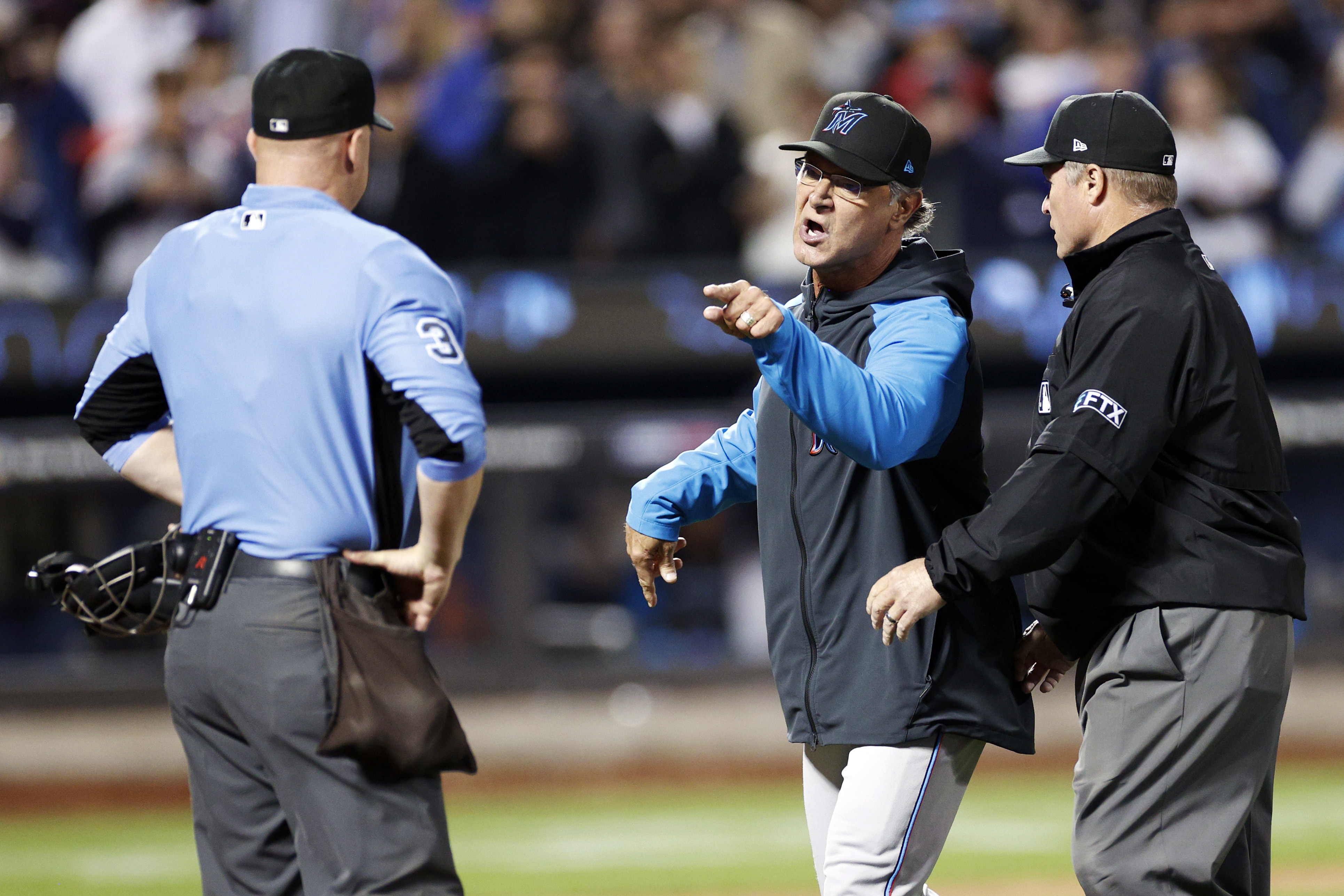 Manager Don Mattingly #8 of the Miami Marlins reacts toward umpire Marvin Hudson #51 (R) and umpire Ryan Blakney #36 (L) after a call during the eighth inning against the New York Mets at Citi Field on September 27, 2022 in the Queens borough of New York City.