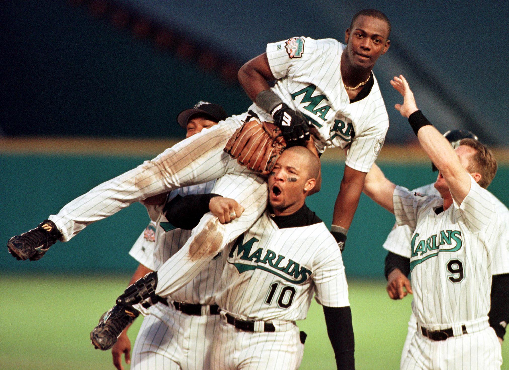 Florida Marlins player Edgar Renteria (TOP) is carried off the field by Gary Sheffield after delivering the game-winning hit 30 September against the San Francisco Giants during their National League Division Series game at Pro Player Stadium in Miami, FL. The Marlins won the game 2-1.