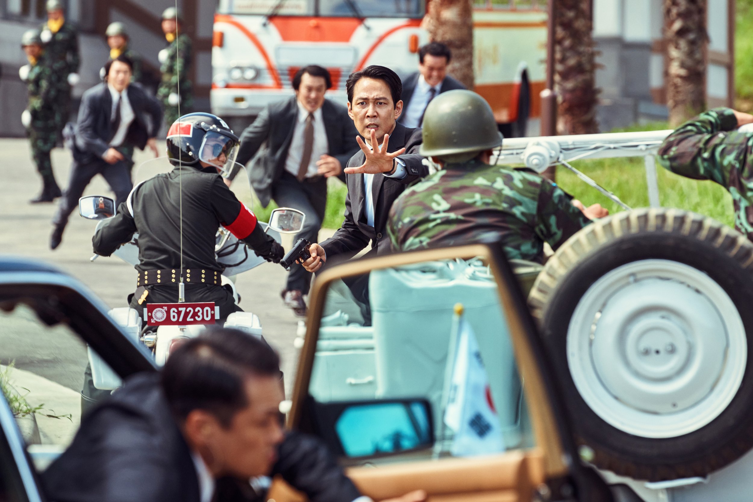 Jung Woo-sung stands in the middle of traffic chaos during an outdoor shootout in Hunt