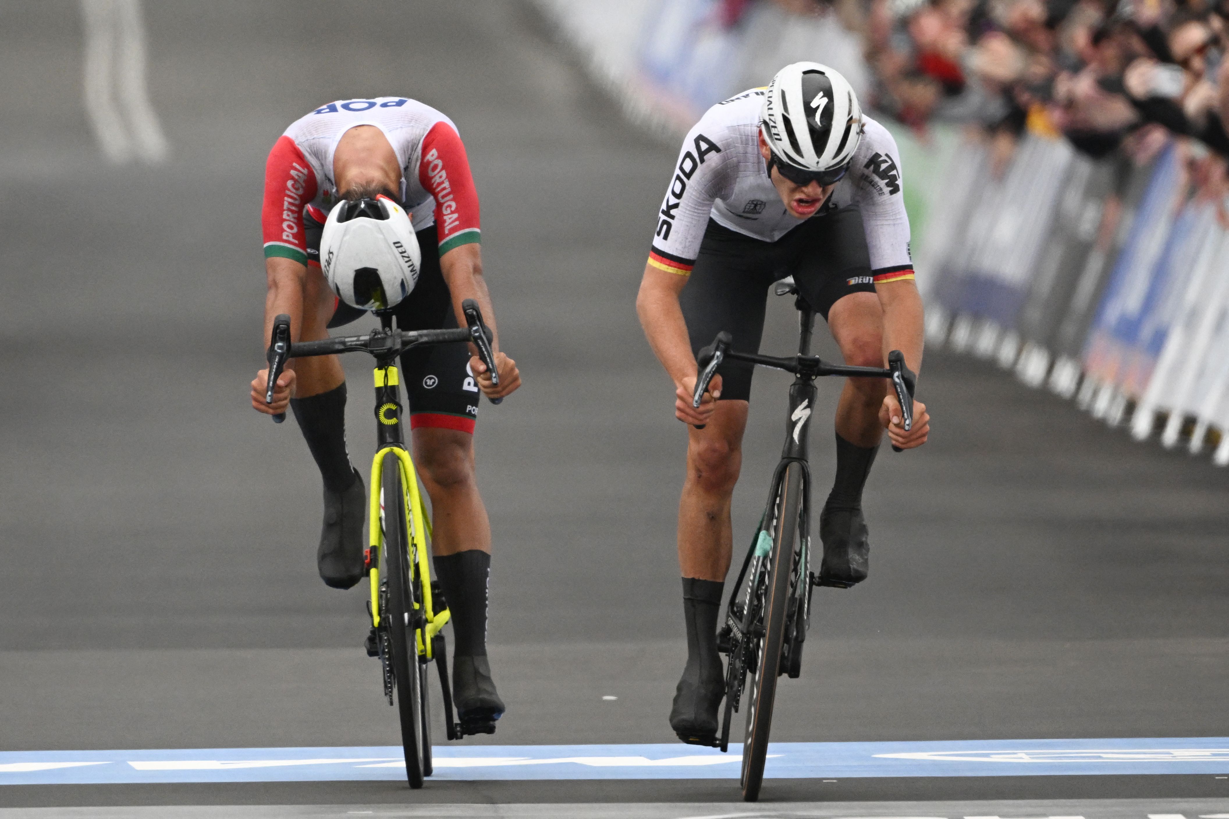 Two cyclists, side by side, sprint towards the finish line in a race to determine who will win and who will finish in second place