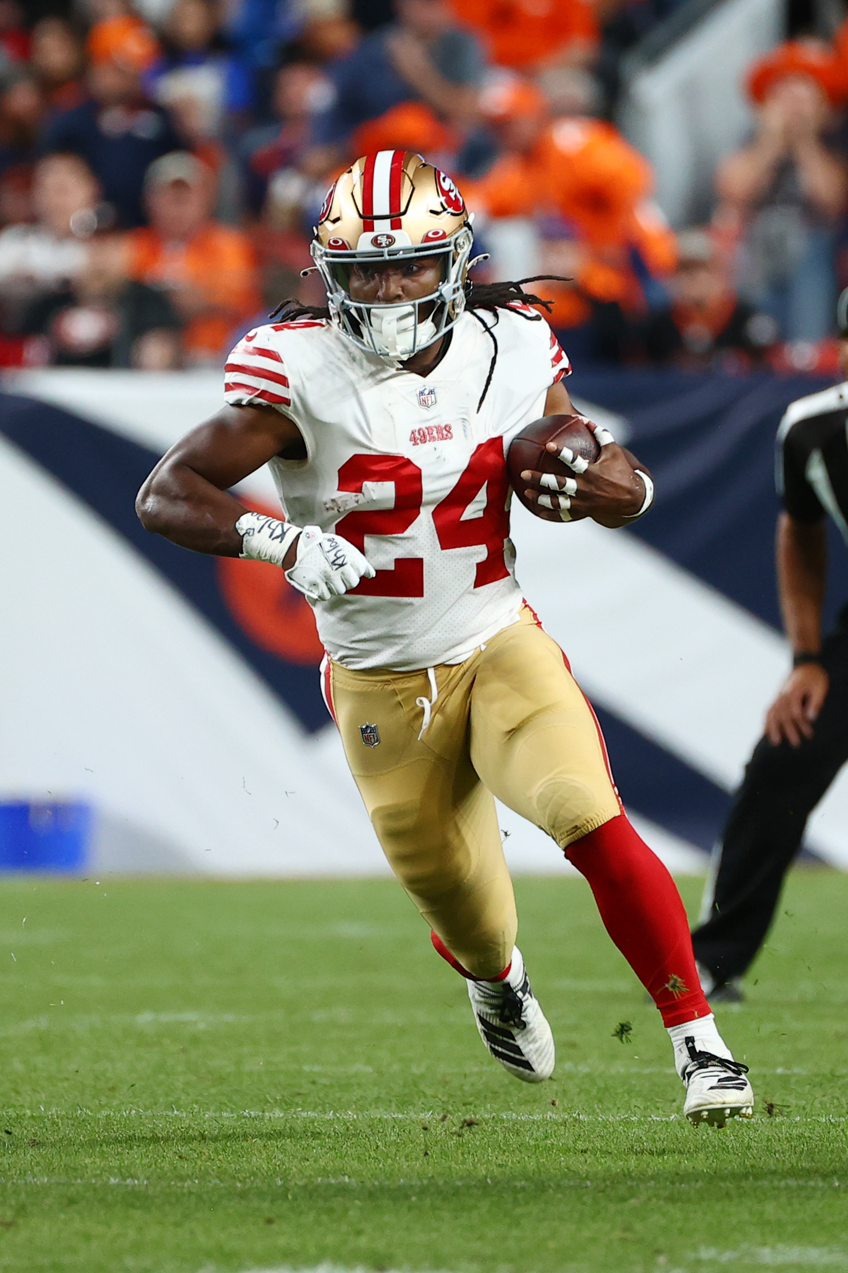 Jordan Mason #24 of the San Francisco 49ers rushes against the Denver Broncos at Empower Field At Mile High on September 25, 2022 in Denver, Colorado.