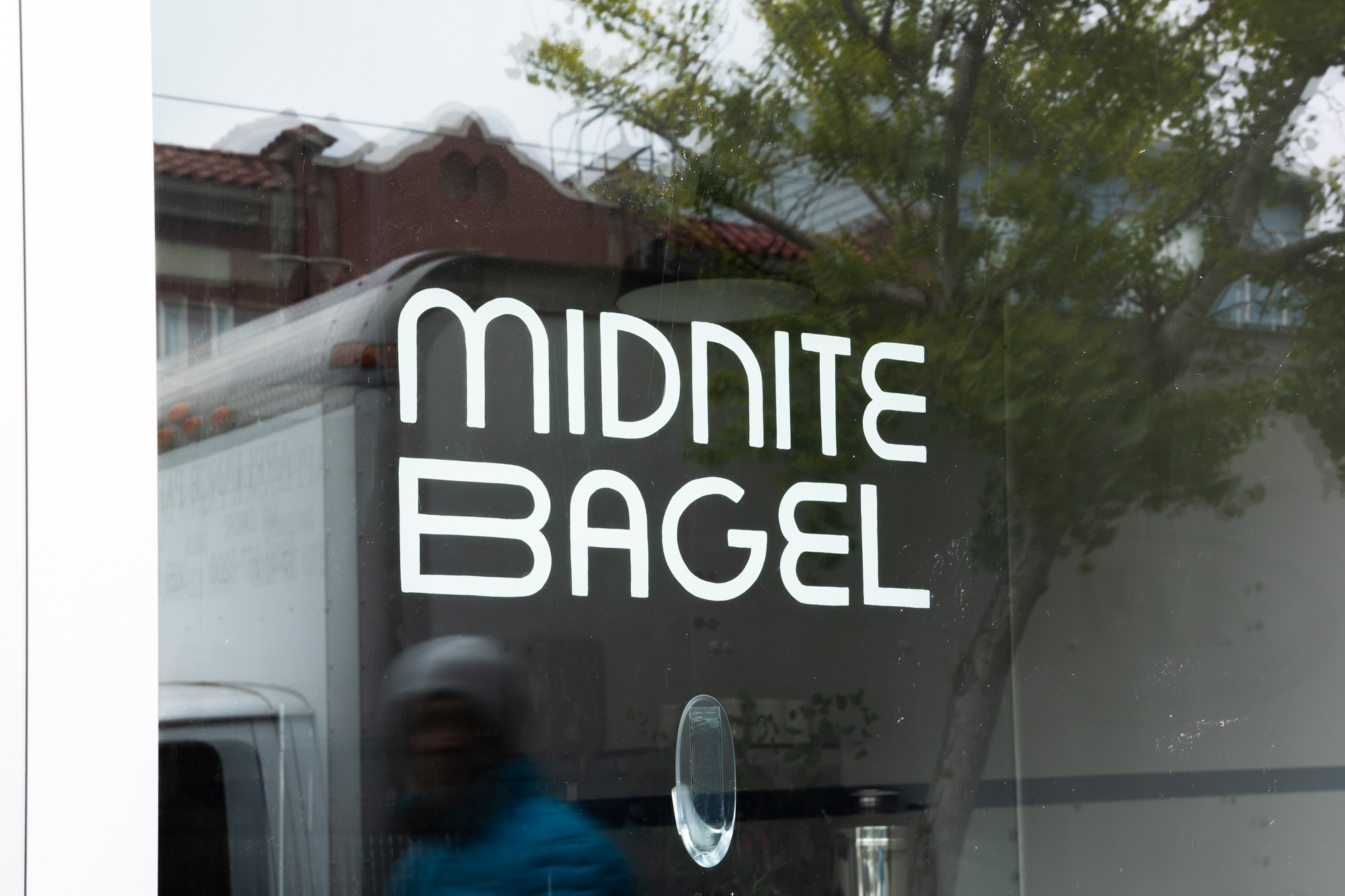 White lettering reads “Midnite Bagel” on a front window.